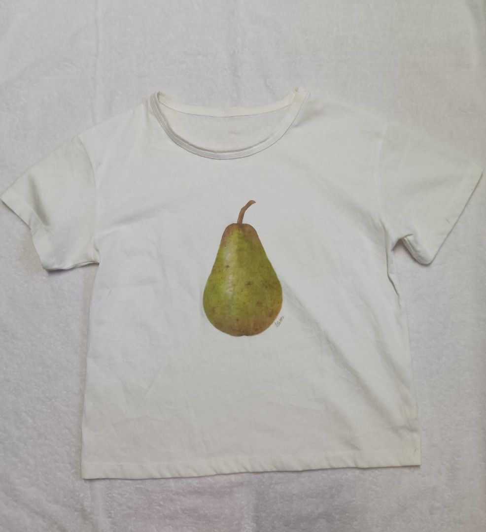 Tietta Pear Graphic Tee (Category: Blouses) located in Malabon City. Submitted by mslalan (Listing ID 1419108568, Image 1). Description: - Tietta brand white t-shirt - Features a pear graphic - Short sleeves - Round neckline - Made of lightweight fabric.