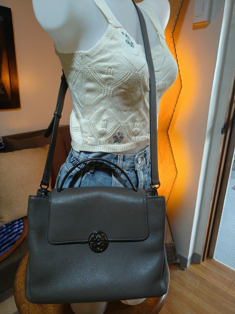 Oryany Satchel Handbag (Category: Luxury Bags & Wallets) located in Quezon City. Submitted by prelovee19 (Listing ID 1419119352, Image 1). Description: - Gray satchel handbag - Top handle and shoulder strap - Flap closure with decorative emblem - Made of leather - Structured shape - Medium size - Suitable for everyday use.