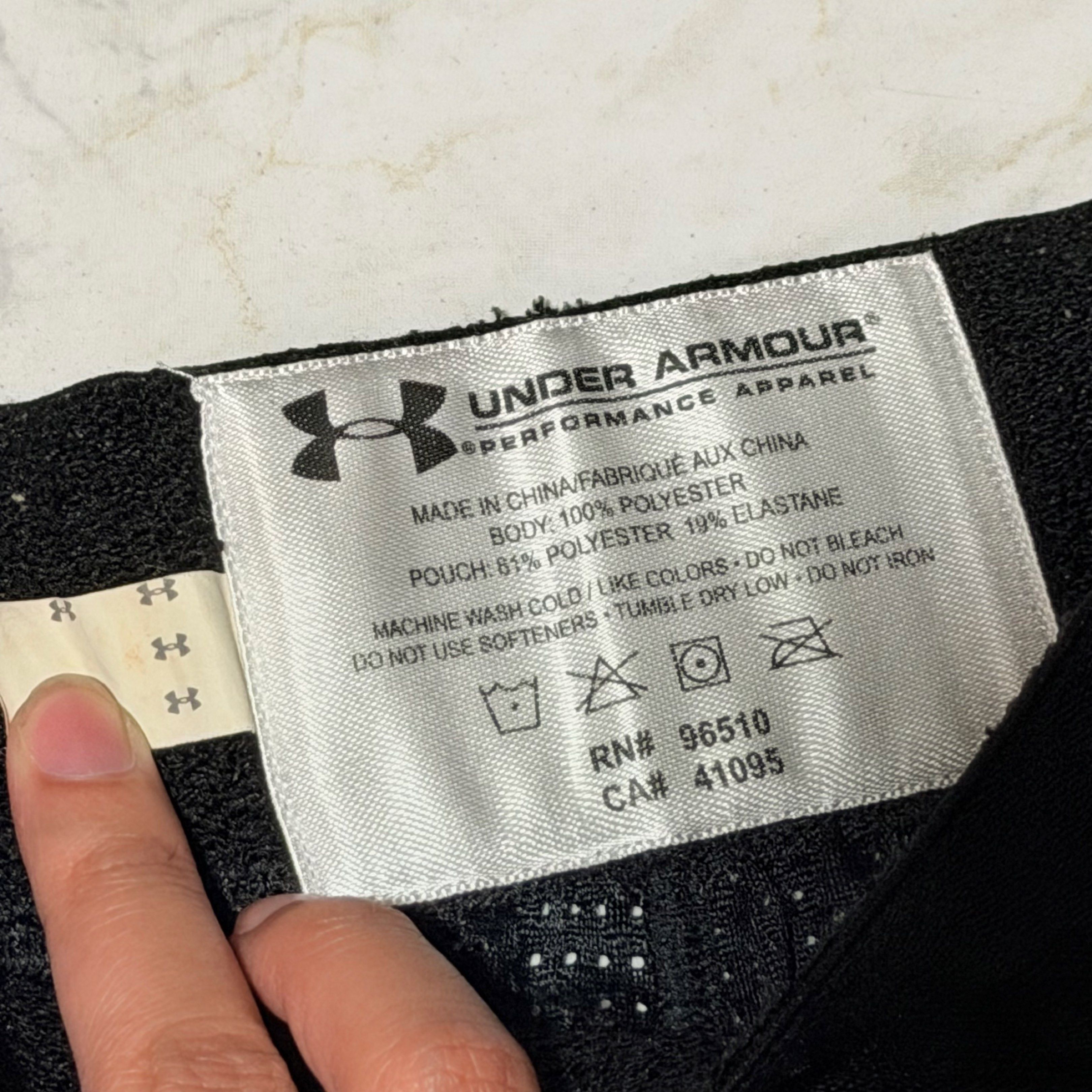 Under Armour Performance Shorts YLG (Category: Shorts) located in Pasig City. Submitted by decluttertrends (Listing ID 1418999566, Image 2). Description: - Under Armour performance shorts - Color: Black - Size: YLG - Features: - Mesh design - Built-in pouch - Padding on front - Material: 100% polyester, 19% elastane - Made in China - Under Armour logo on leg and waistband.