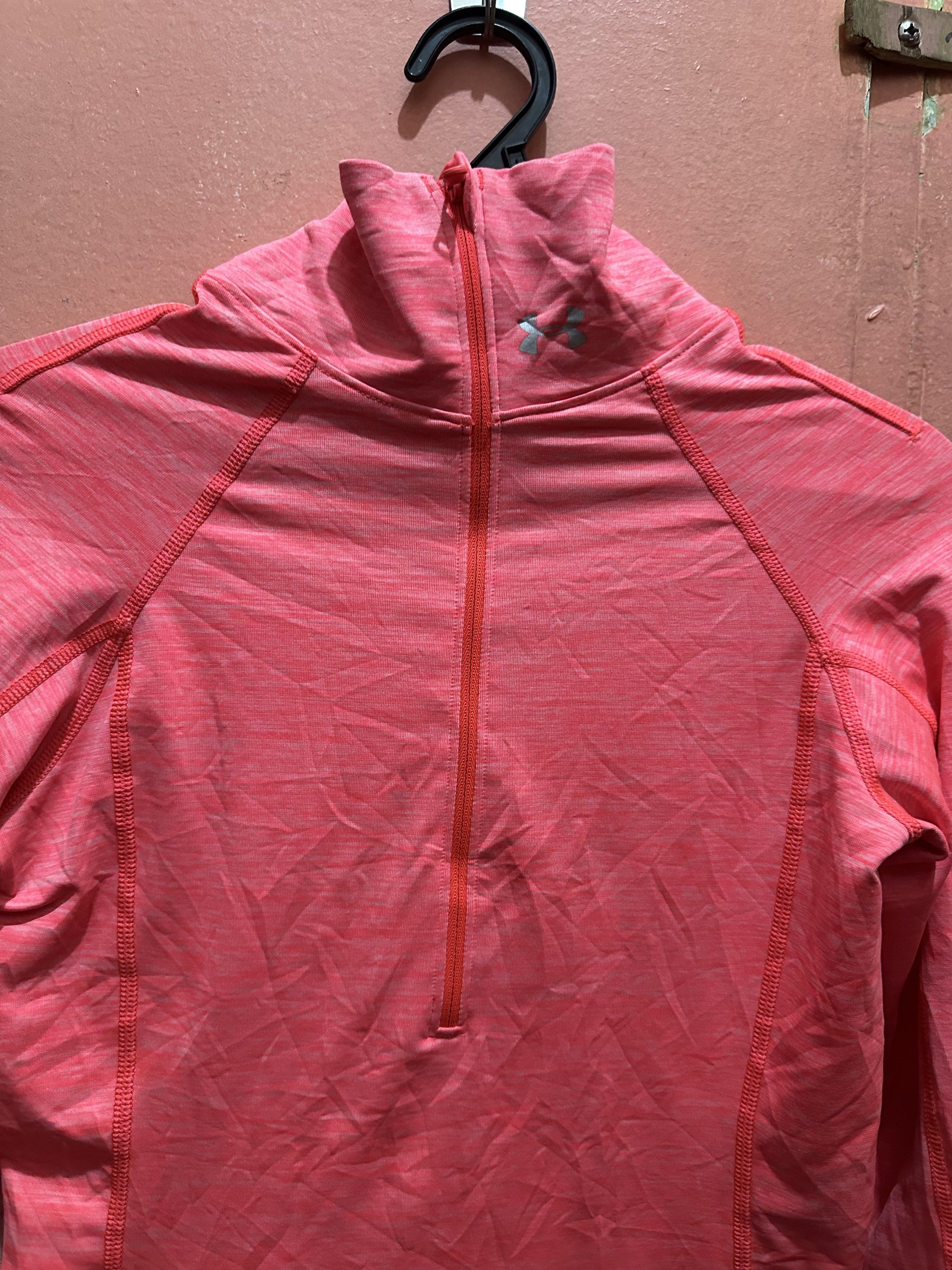 Under Armour running yoga jacket (Category: Activewear) located in Manila. Submitted by juanabanana (Listing ID 1419176646, Image 3). Description: - Under Armour ColdGear Pullover - Color: Pink - Size: Small - Features: Half-zip, long sleeves with thumbholes - Logo: Under Armour logo on chest - Material: Lightweight athletic material - Suitable for cooler weather - Measurements: 16.5 x 26 Needs wash.