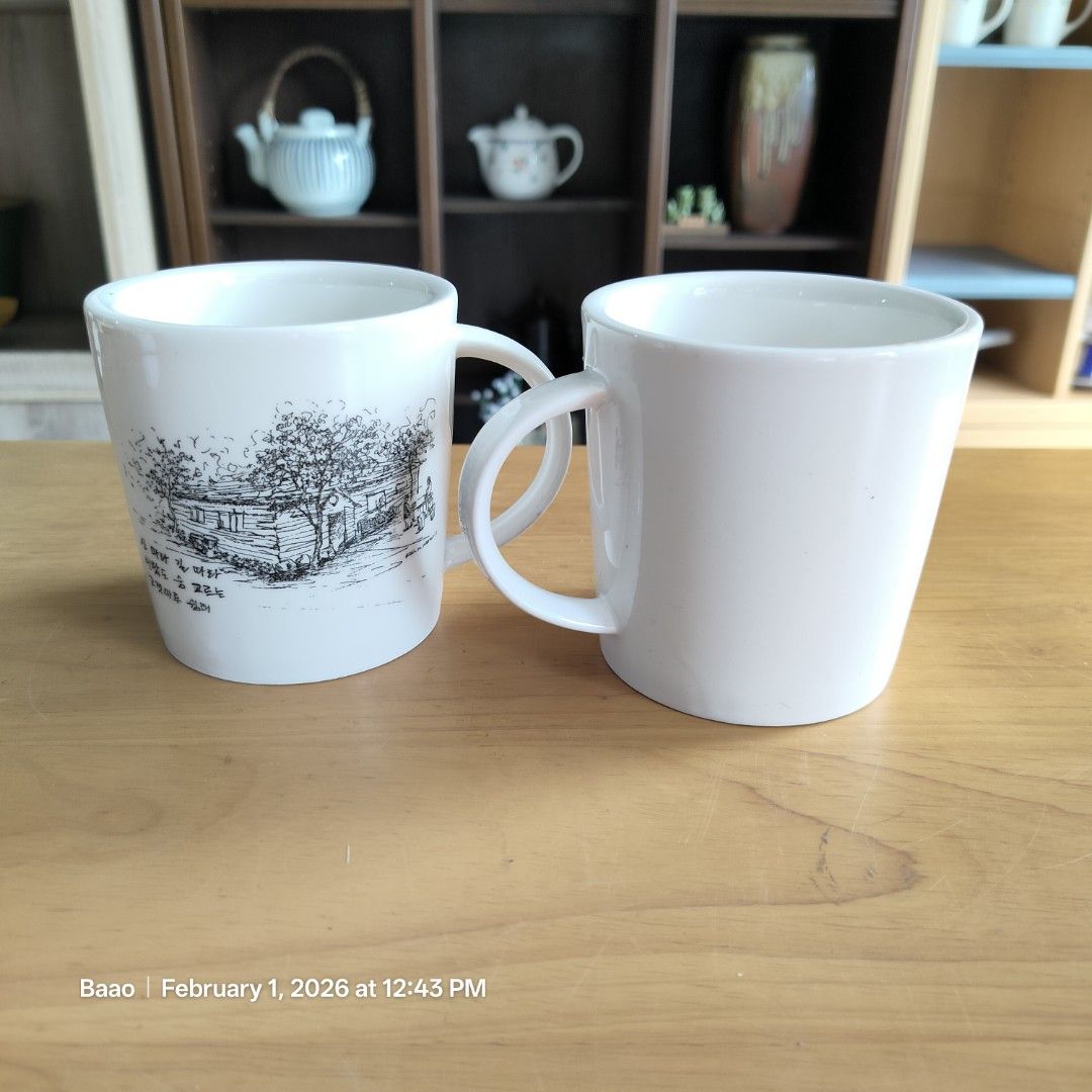 White Ceramic Mug with Illustration (Category: Coffee & Tea Tableware) located in Baao. Submitted by all.things.japan (Listing ID 1419016822, Image 3). Description: COUPLE ART MUGS - Set of two white ceramic mugs - thicker than standard mugs - Features black and white illustrations of houses and trees - Simple, rounded design with handles - Clean and ready for use - Ideal for coffee, tea, and other beverages - 3.75 inches (h) x 3.6 inches (d) Min