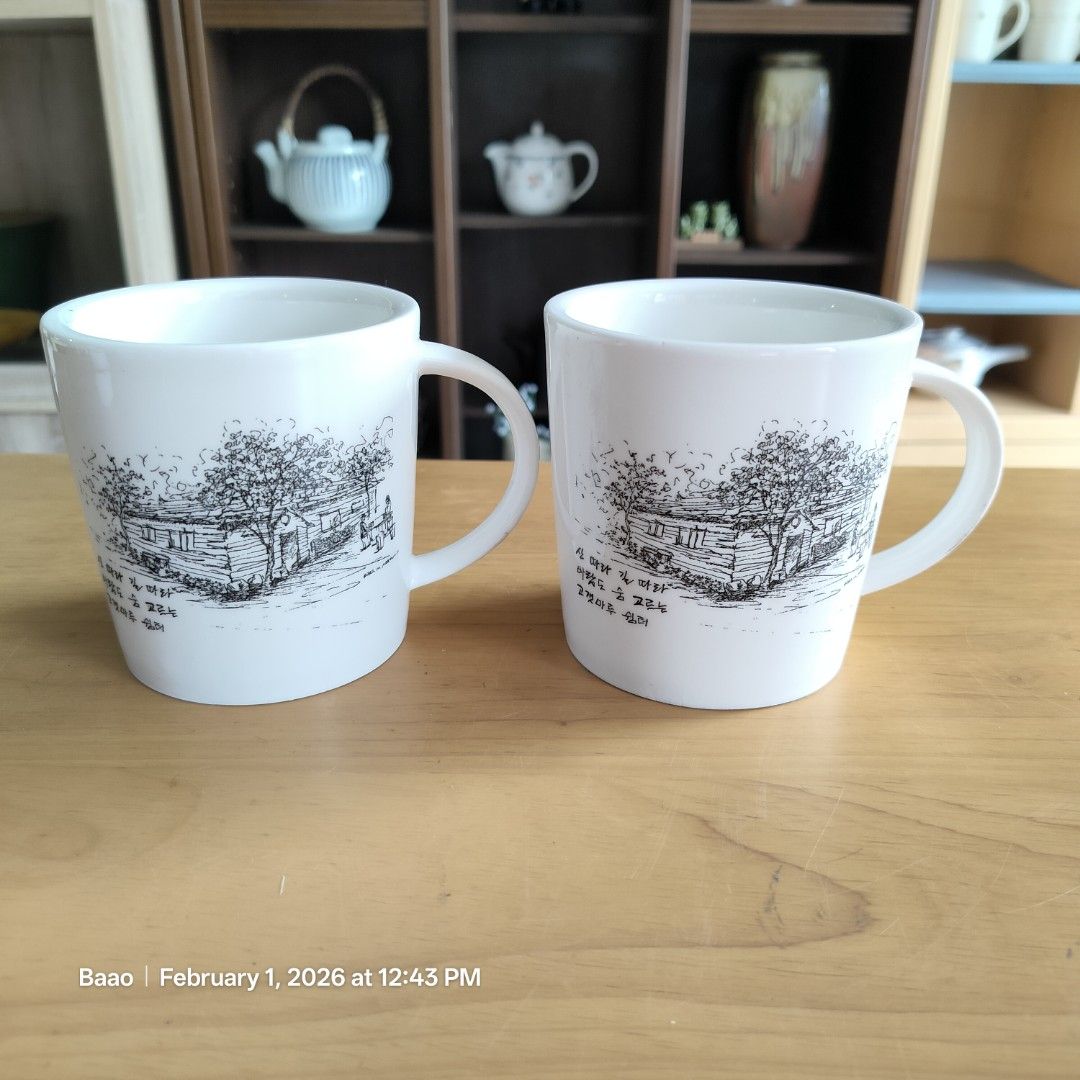 White Ceramic Mug with Illustration (Category: Coffee & Tea Tableware) located in Baao. Submitted by all.things.japan (Listing ID 1419016822, Image 2). Description: COUPLE ART MUGS - Set of two white ceramic mugs - thicker than standard mugs - Features black and white illustrations of houses and trees - Simple, rounded design with handles - Clean and ready for use - Ideal for coffee, tea, and other beverages - 3.75 inches (h) x 3.6 inches (d) Min
