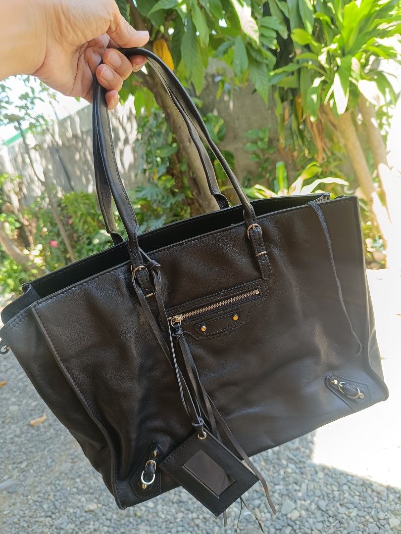 Balenciaga Papier Tote Bag (Category: Luxury Bags & Wallets) located in Mangaldan. Submitted by mceseucap18107 (Listing ID 1420800119, Image 1). Description: - Black leather Balenciaga tote bag -Coded -Expandable side zippers - Multiple interior pockets - Front zip pocket - Double handles and shoulder strap - Interior zip pocket with Balenciaga Paris label - Made in Italy - Includes serial number.