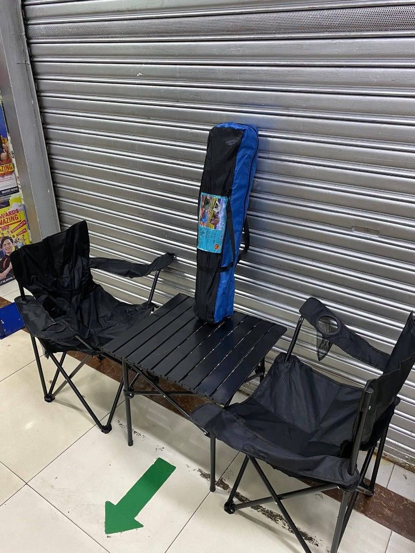 Camping Table and Chairs Set (Category: Hiking & Camping) located in Taguig. Submitted by diannecaya86853 (Listing ID 1420903493, Image 1). Description: Camping set includes a foldable table and two chairs. The chairs have armrests and a cup holder. The set comes with a carrying bag for easy transport and storage. The table and chairs are black. Perfect for outdoor activities like camping, picnics, or beach trips..