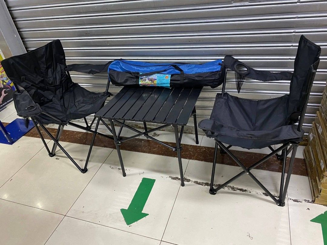 Camping Table and Chairs Set (Category: Hiking & Camping) located in Taguig. Submitted by diannecaya86853 (Listing ID 1420903493, Image 2). Description: Camping set includes a foldable table and two chairs. The chairs have armrests and a cup holder. The set comes with a carrying bag for easy transport and storage. The table and chairs are black. Perfect for outdoor activities like camping, picnics, or beach trips..