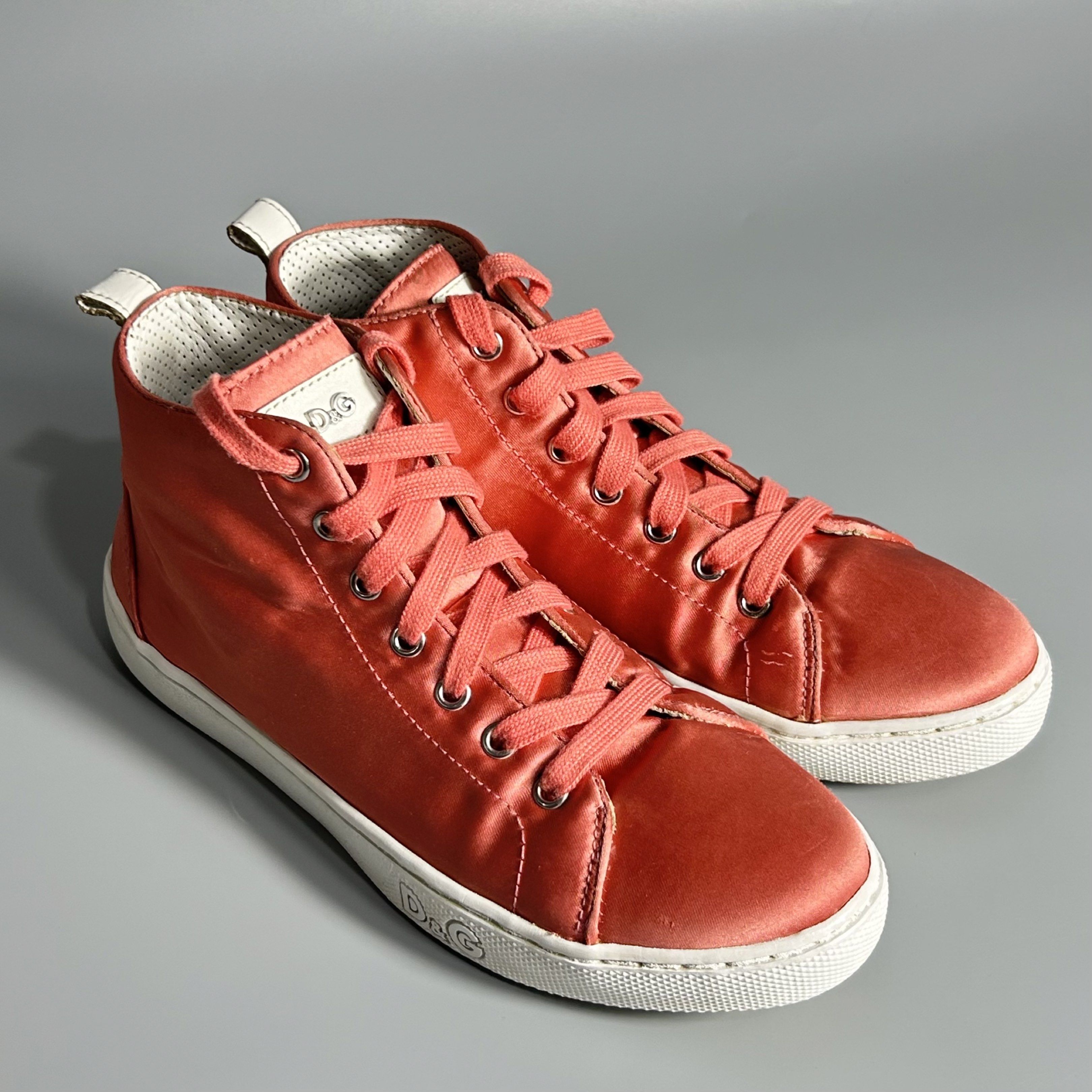 D&G Pink Satin High-Top Sneakers (Category: Sneakers) located in Cavite. Submitted by datsoretro (Listing ID 1420927740, Image 1). Description: - D&G high-top sneakers - Peach satin upper - White soles with D&G logo - Matching peach laces - White leather detail on the back - D&G logo on the interior - Size 35 - Visible bubbles/creases due to use.