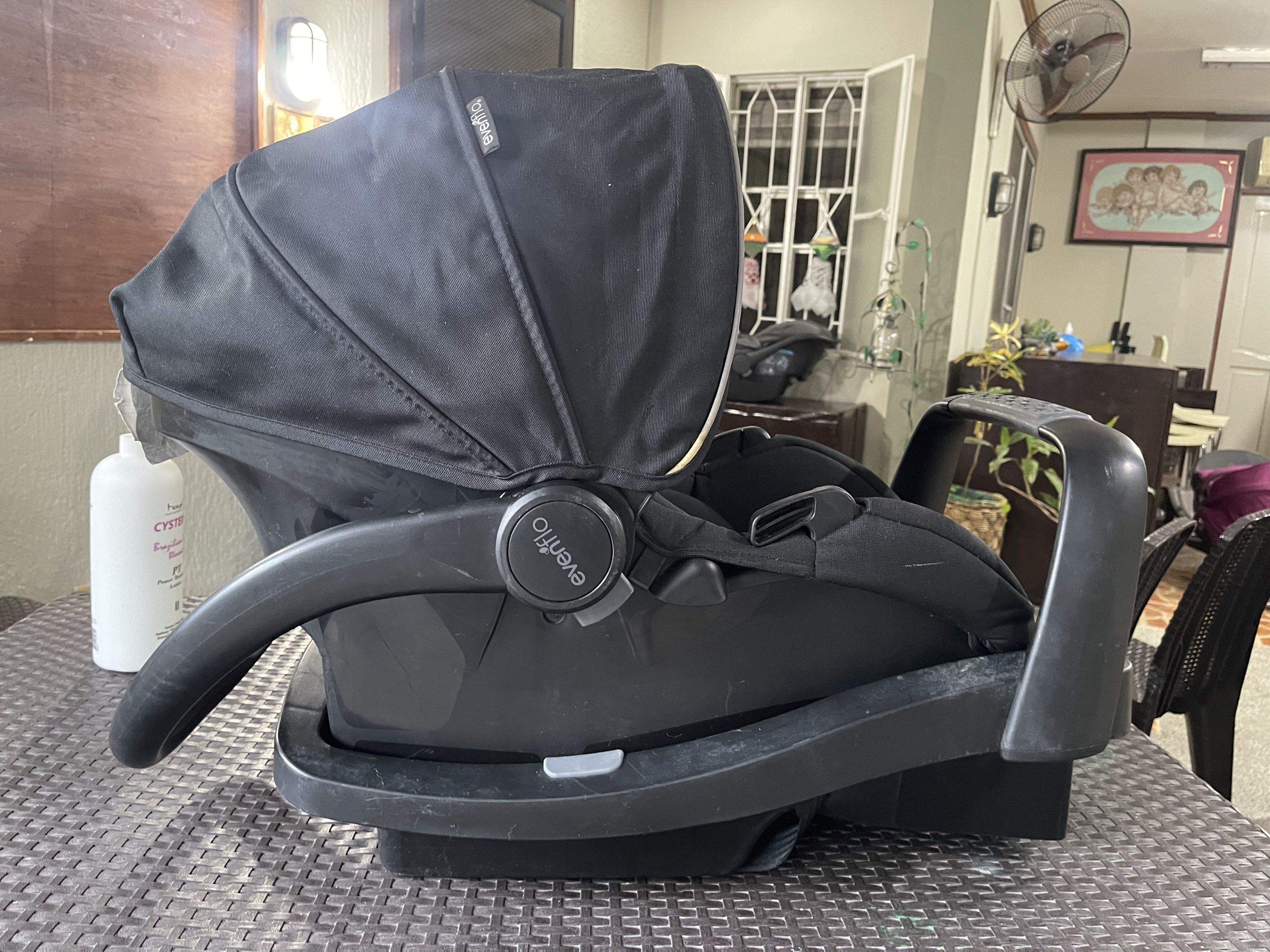 Evenflo Infant Car Seat (Category: Car Seats) located in Quezon City. Submitted by tabbybabby (Listing ID 1420854526, Image 1). Description: - Evenflo infant car seat - Black color - Includes base for easy installation - Features a canopy - Has a carrying handle - Equipped with safety straps.