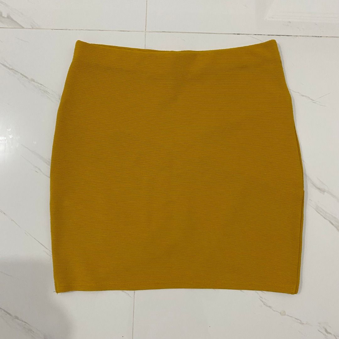 Forever 21 Mustard Yellow Mini Skirt (Category: Skirts) located in San Fernando. Submitted by deku_off (Listing ID 1420892435, Image 3). Description: Mustard yellow mini skirt from Forever 21. Features a ribbed texture and a unique criss-cross design at the front. The skirt is a size S. Made in Cambodia. A versatile piece that can be dressed up or down. Perfect for adding a pop of color to your wardrobe..