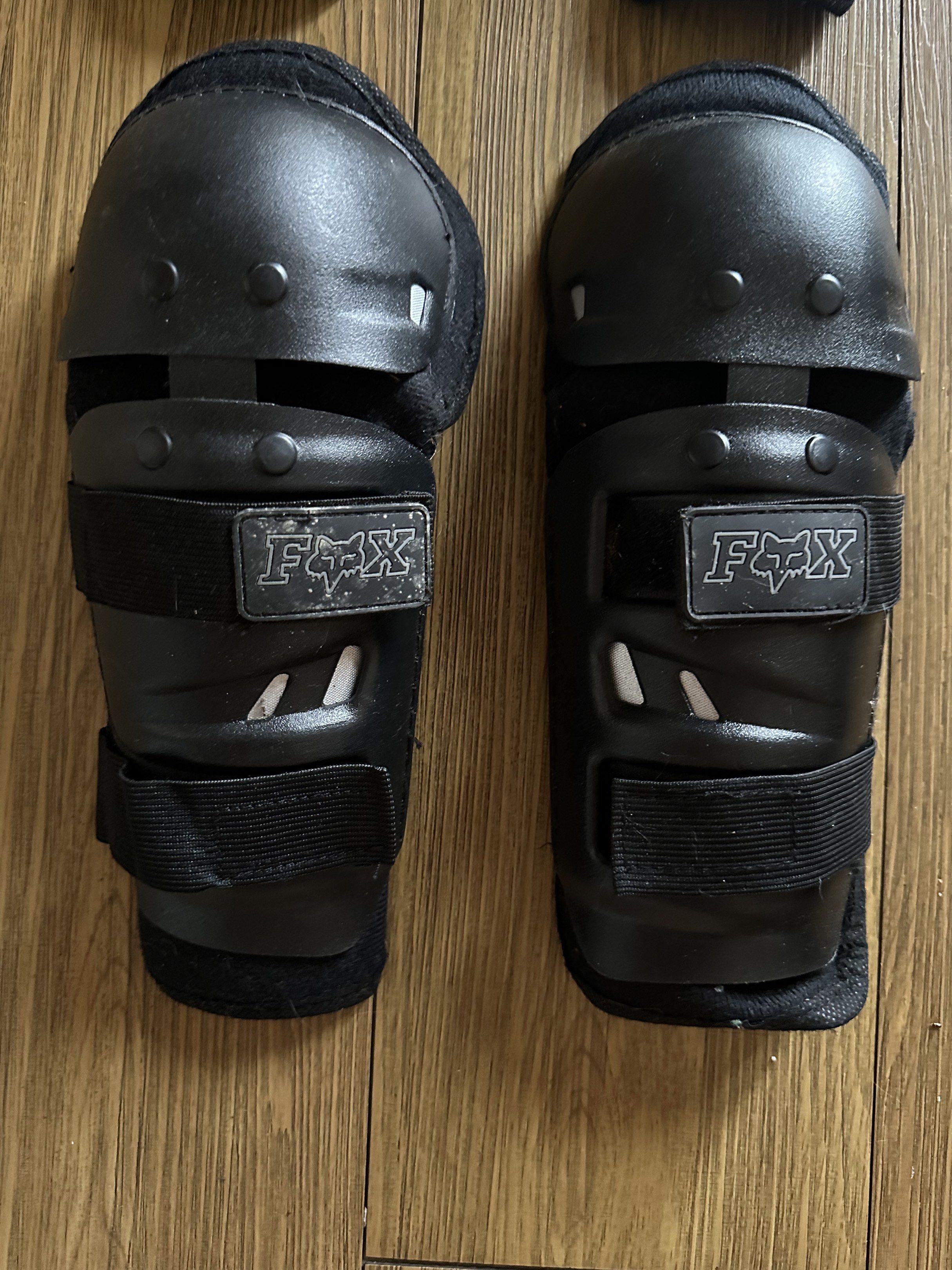 Fox Knee and Shin Guards (Category: Other Sports Equipment and Supplies) located in Caloocan City. Submitted by 2ndfash (Listing ID 1420816447, Image 2). Description: Set of Fox knee and shin guards. Features adjustable straps for a secure fit. The guards are black. The Fox logo is visible on the straps. Designed to protect knees and shins. Suitable for various activities..