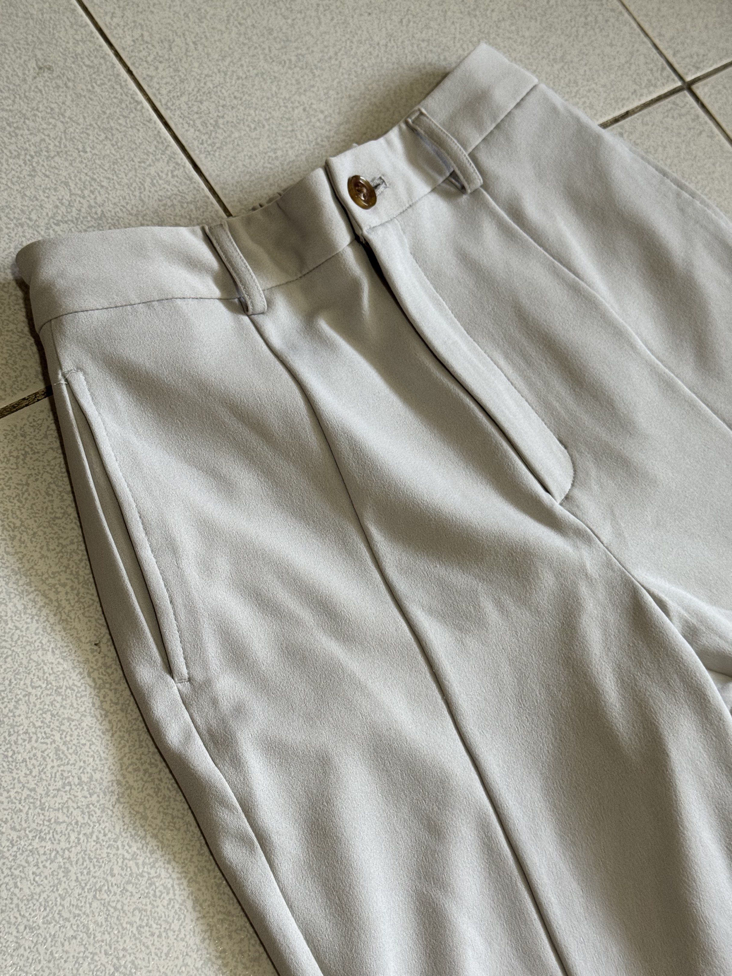 RUSH❌GU Flare Pants (Category: Other Bottoms) located in Palayan City. Submitted by decluttering_2018 (Listing ID 1420935220, Image 2). Description: - GU light grey flare pants - Size: M - Features: - Button and zipper closure - Side pockets - Pleated front - Elastic waistband at the back - Material: Polyester and polyurethane blend.