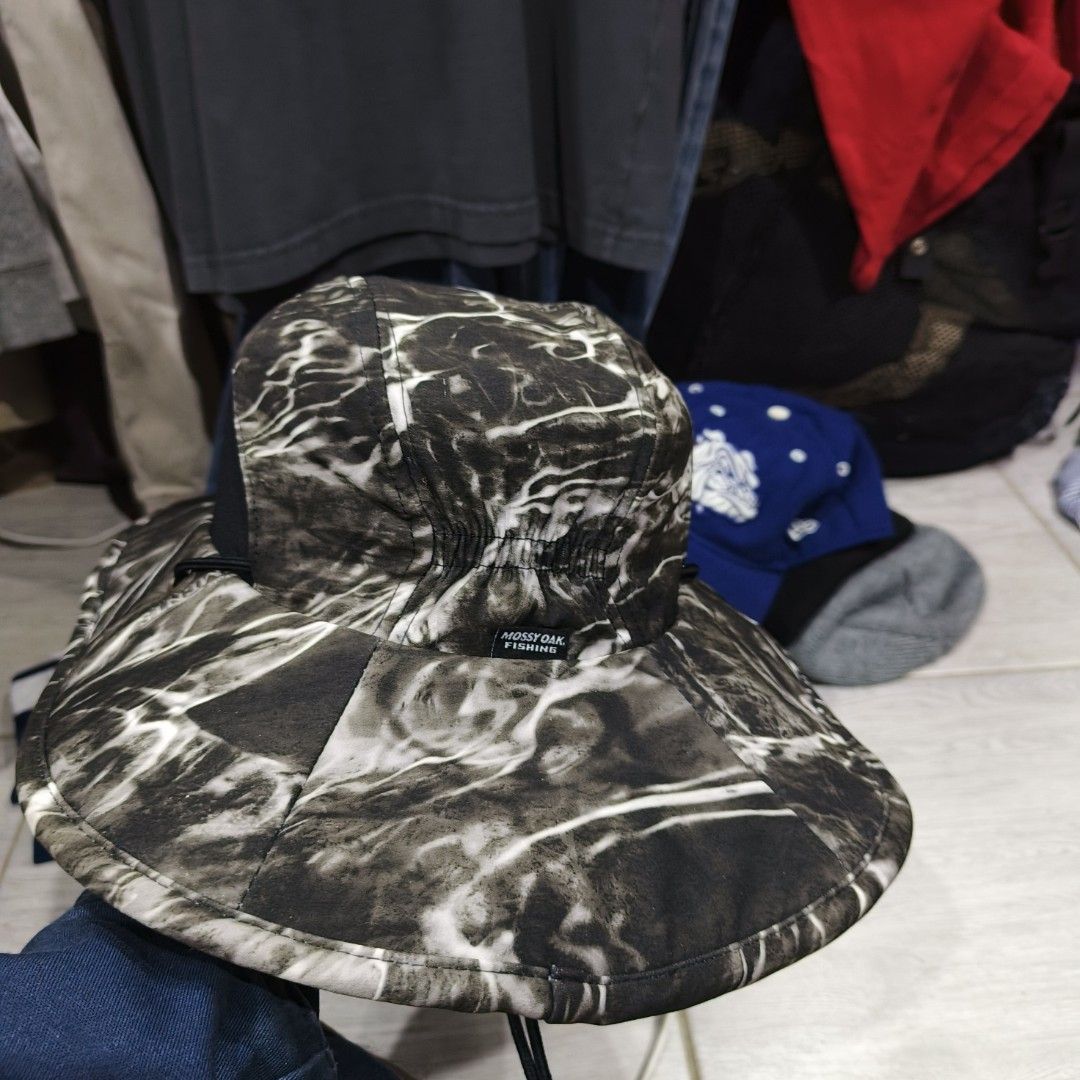 Mossy Oak Fishing Camo Hat (Category: Caps & Hats) located in Bayombong. Submitted by easyflip_04 (Listing ID 1420918539, Image 1). Description: Mossy Oak Fishing hat features a camouflage pattern. It has a wide brim and a black band around the crown. The hat also has a chin strap. The Mossy Oak Fishing logo is prominently displayed on the front..