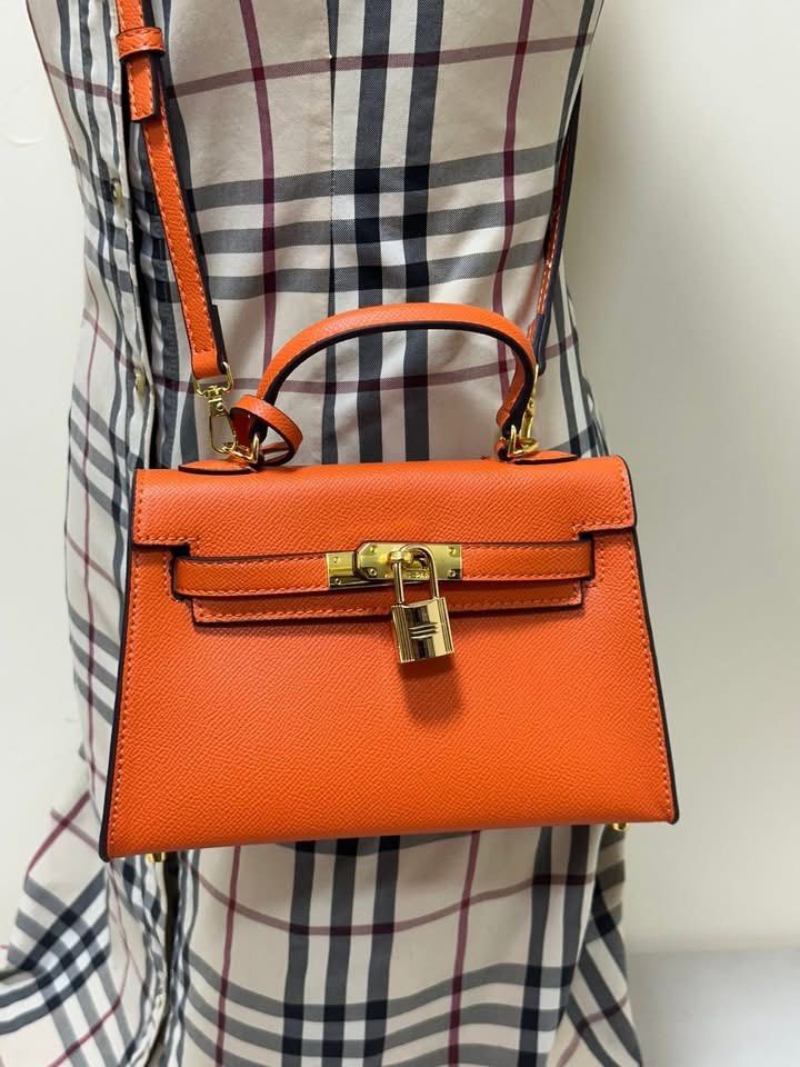 Orange Handbag with Lock and Key (Category: Luxury Bags & Wallets) located in Los Banos. Submitted by ditasbautista2329 (Listing ID 1420933685, Image 2). Description: - Orange handbag - Top handle and detachable shoulder strap - Gold-colored lock with keys - Matching orange interior - Structured design - Gold-toned hardware - Small size, ideal for essentials.