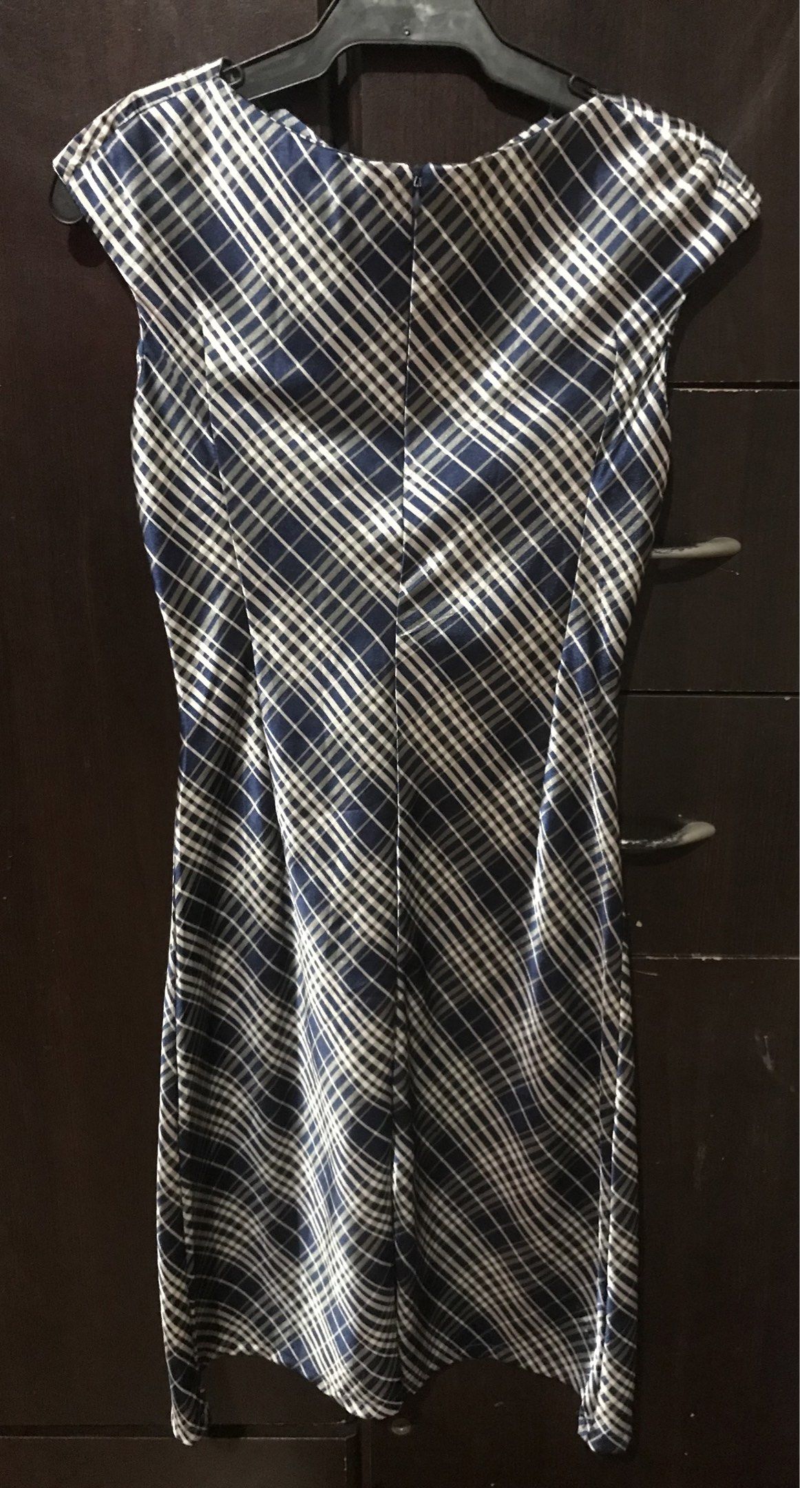 Plaid Sleeveless Dress (Category: Dresses) located in Rizal. Submitted by Houseoftiki (Listing ID 1420846027, Image 2). Description: - Sleeveless plaid dress in navy blue and white - Unique neckline design - Smooth, possibly satin-like fabric - Fitted silhouette - Knee-length.