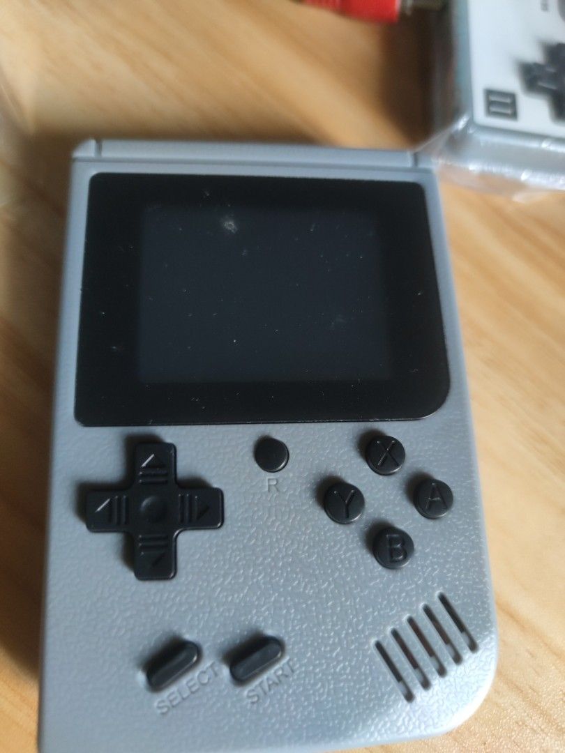 Retro Game Console Plus (Category: Others) located in Cavite. Submitted by Combiishop (Listing ID 1420749027, Image 2). Description: - Retro game console with handheld and external controller. - Includes charging cable and AV cable for TV connection. - Features a built-in screen and buttons. - Comes with the original box. - Portable gaming experience..