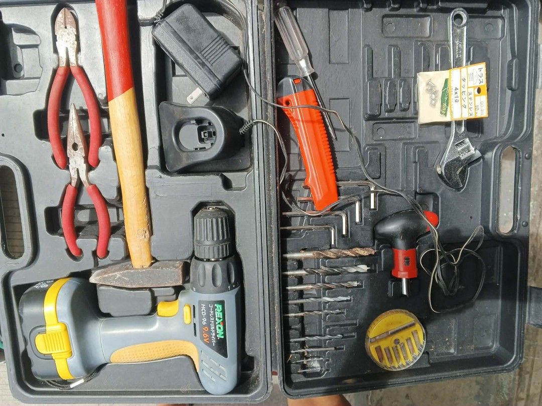 Rexon 9.6V Cordless Drill Tool Kit (Category: Construction Tools & Equipment) located in Caloocan City. Submitted by surplusandbnewshop (Listing ID 1420833395, Image 2). Description: Tool kit includes a Rexon 9.6V cordless drill, various drill bits, pliers, a hammer, and other hand tools. It comes with a charger. The kit is housed in a black carrying case for easy storage and transport. Perfect for home repairs and DIY projects..