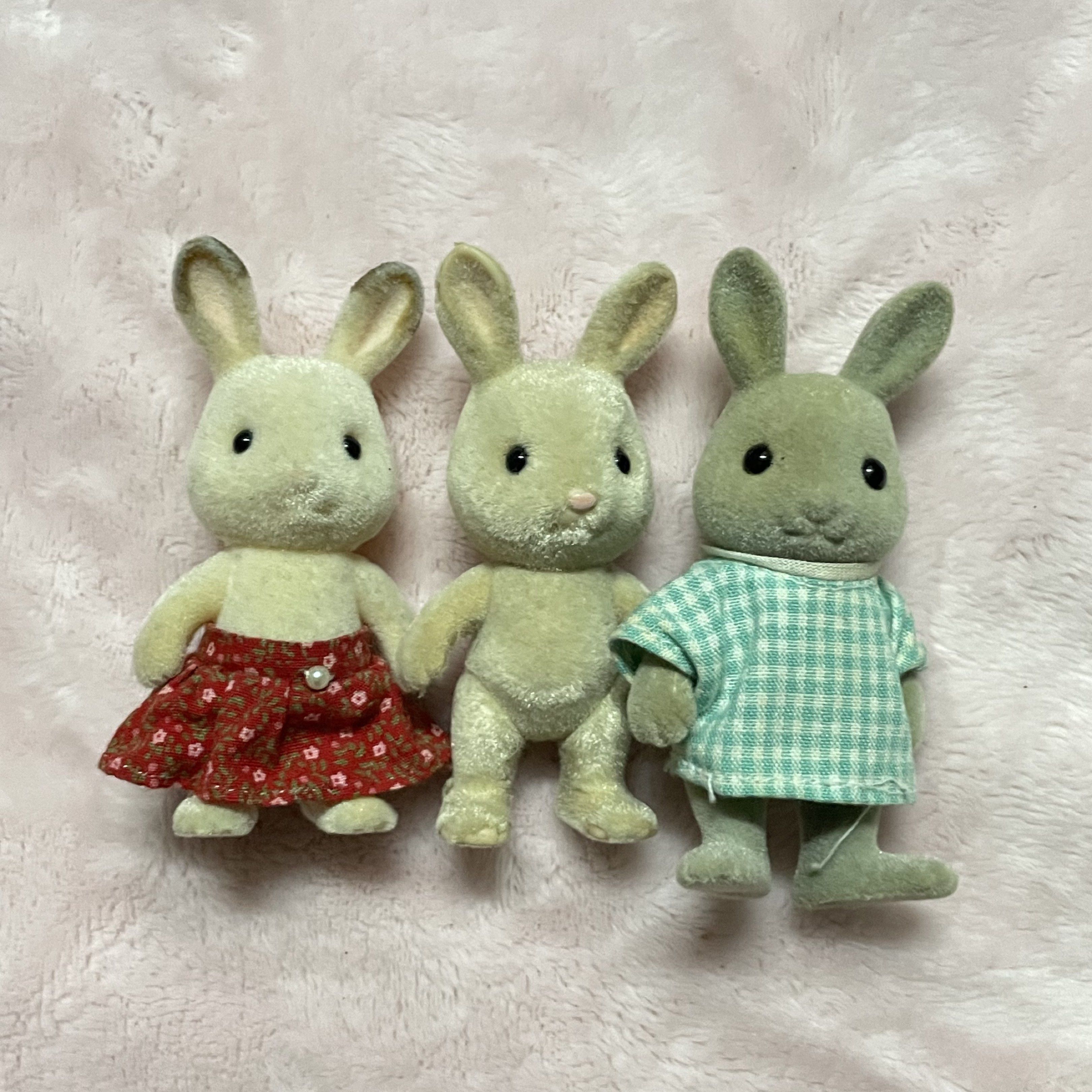 Sylvanian Families Rabbit Figures Set (Category: Figurines & Statues) located in Manila. Submitted by annemargarettes (Listing ID 1420862001, Image 1). Description: - Set of three Sylvanian Families rabbit figures - Includes: - Rabbit with red floral skirt - Rabbit without clothing - Rabbit with green checkered shirt - Standing pose - Flocked surfaces - Detailed features.