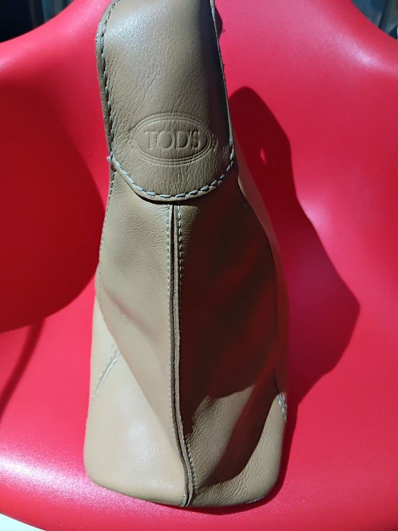 Tod's Genuine Leather Shoulder Bag (Category: Luxury Bags & Wallets) located in Quezon City. Submitted by threetwotwo2ndaccount (Listing ID 1420801691, Image 2). Description: - Authentic Tod's shoulder bag - Tan leather exterior - Secure zipper closure - Interior lined with dark fabric - Made in Italy - Features the Tod's logo - Genuine Lampo zipper size: H-11",L-19",W-6" issue: putol ung zipper puller no inclusion .