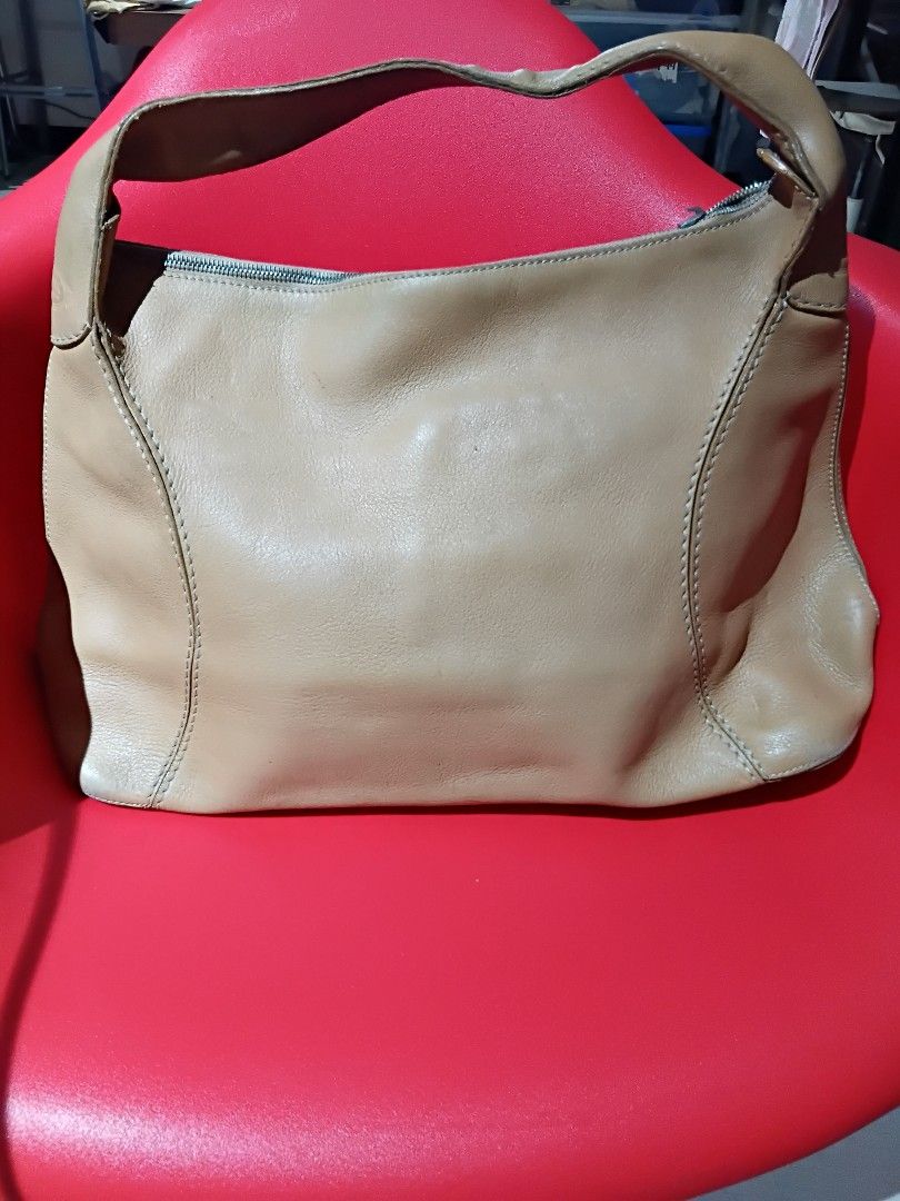 Tod's Genuine Leather Shoulder Bag (Category: Luxury Bags & Wallets) located in Quezon City. Submitted by threetwotwo2ndaccount (Listing ID 1420801691, Image 1). Description: - Authentic Tod's shoulder bag - Tan leather exterior - Secure zipper closure - Interior lined with dark fabric - Made in Italy - Features the Tod's logo - Genuine Lampo zipper size: H-11",L-19",W-6" issue: putol ung zipper puller no inclusion .