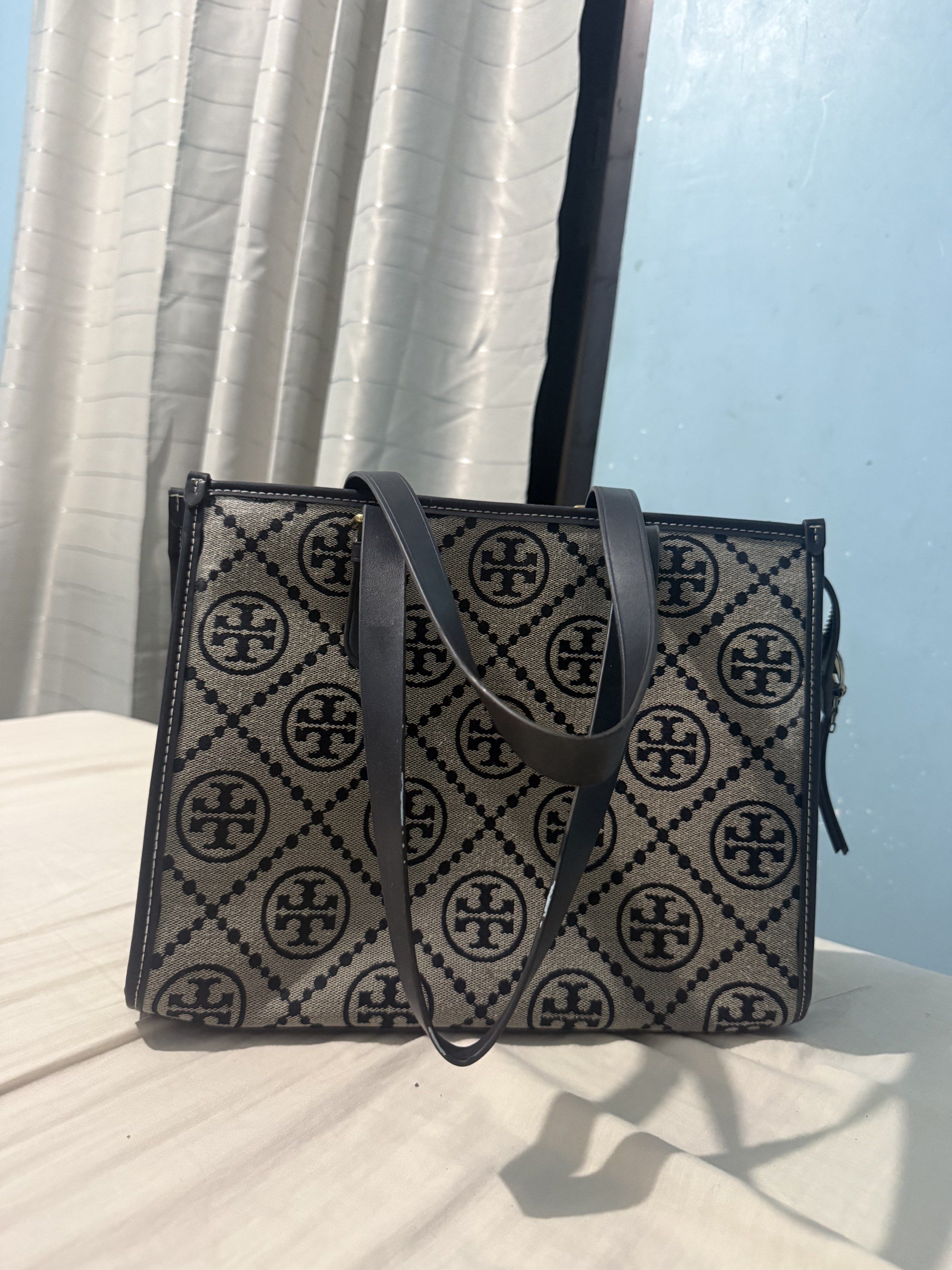 Tory Burch T Monogram Tote Bag Medium (Category: Luxury Bags & Wallets) located in Naga. Submitted by gst.grovest (Listing ID 1420859594, Image 2). Description: - Tory Burch T Monogram Tote Bag (Medium Size) - Features the iconic T Monogram pattern - Spacious interior - High-quality materials - Authentic Tory Burch Issue: - White Stain ( Note Sure if Washable).