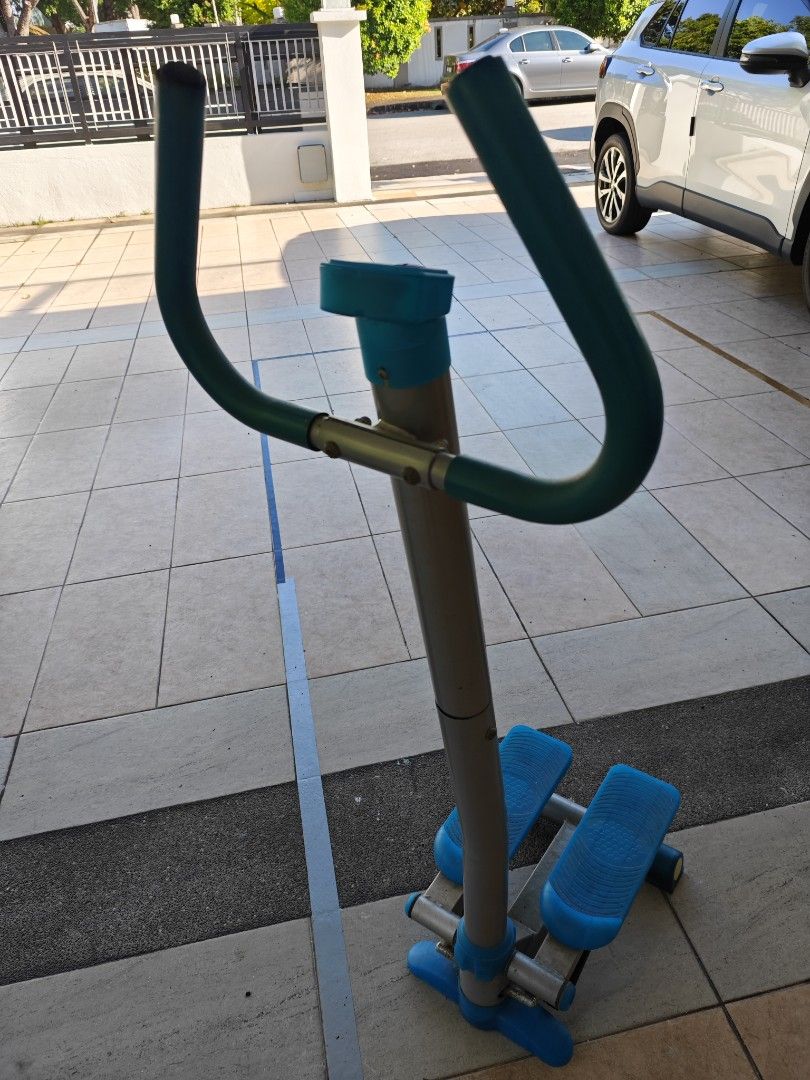 Vertical Stepper Exercise Machine (Category: Cardio & Fitness Machines) located in Shah Alam. Submitted by steward123 (Listing ID 1420756693, Image 3). Description: Vertical stepper exercise machine features blue foot pedals and handles. It has a silver frame with blue accents. It is designed for stepping exercises to help improve fitness..