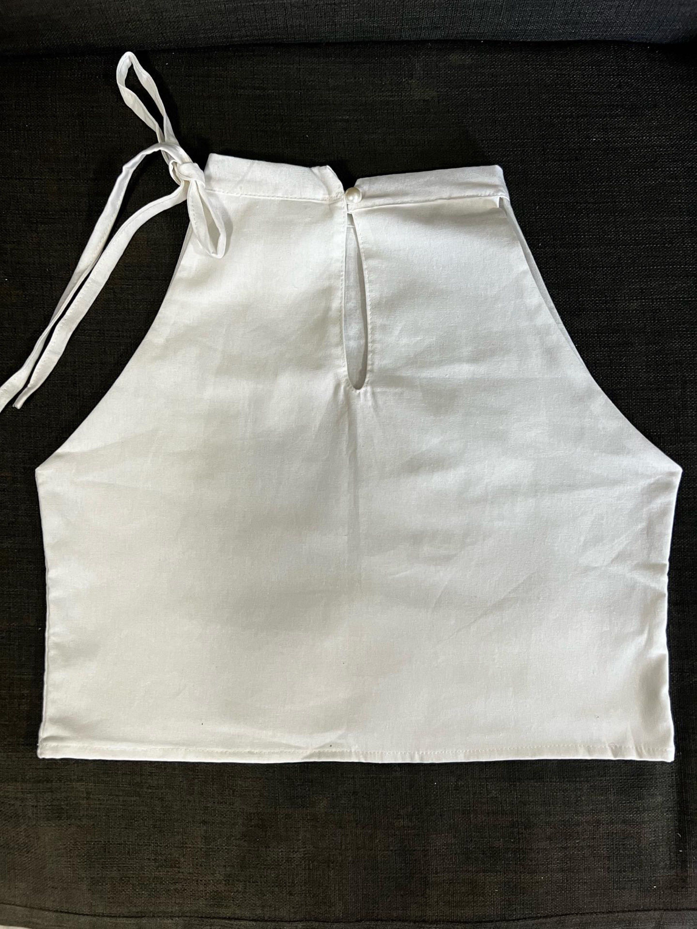 White Halter Top (Category: Sleeveless) located in Pasig City. Submitted by decluttertrends (Listing ID 1420768386, Image 3). Description: Custom top - off white (double fabric) Bust- 33” Length 16” from top of clothing Notes: v sides details, with slit opening and button at the back, with one side thin ties design - White halter top - Tie closure - Keyhole back detail - High neckline - Sleeveless - Made of cotton - Casual wear.
