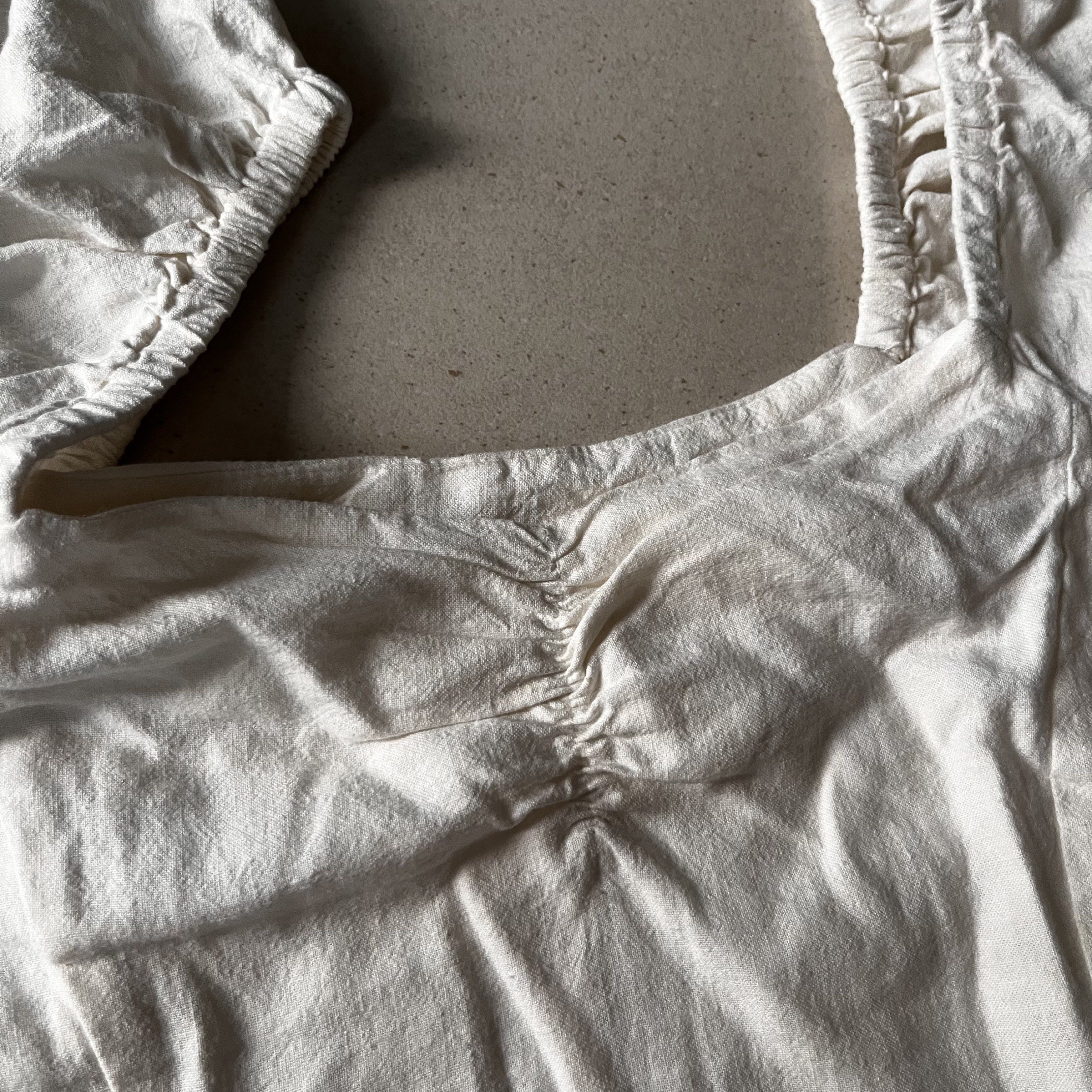 White Puff Sleeve Square Neckline Ruched Front Linen Top (Category: Blouses) located in Santa Rosa. Submitted by blancrealm (Listing ID 1420849238, Image 3). Description: Model measurements: - Height: 160cm - Shoulders: 42cm - Waist: 27" - Hips: 35" - I feel like this would best fit XS-S - White top with square neckline, puff sleeves, and ruched bust. Fitted silhouette. Lightweight fabric. Great for casual or semi-formal wear..