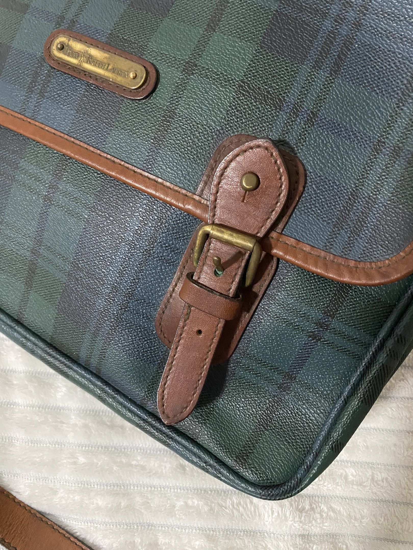 Authentic Polo Ralph Lauren Plaid Messenger Bag (Category: Luxury Bags & Wallets) located in Santa Rosa. Submitted by sassycollection. (Listing ID 1420943151, Image 2). Description: - Authentic Polo Ralph Lauren messenger bag - Green and blue plaid pattern - Brown leather trim - Adjustable shoulder strap - Flap closure with buckles - Main compartment and inner pocket - Polo Ralph Lauren logo detail.