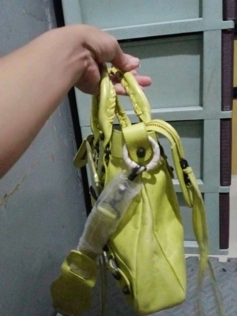 Balenciaga Classic City Handbag (Category: Luxury Bags & Wallets) located in Bacoor. Submitted by pjp26 (Listing ID 1420956932, Image 3). Description: -Balenciaga Classic City handbag - Stunning yellow-green color - Top handle and detachable shoulder strap - Exterior details - Includes a small mirror - Secure zipper closure - Interior tag - Made in Italy - Zipper brand: Lampo.