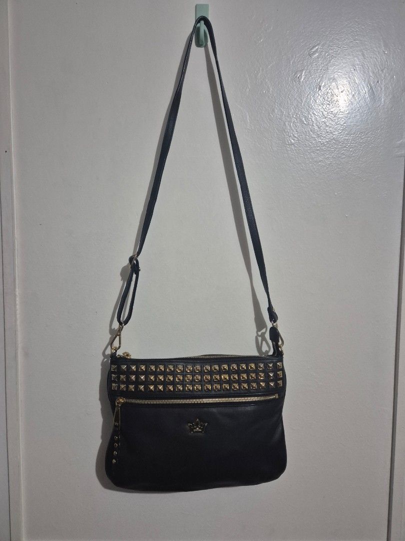 Black Studded Crossbody Bag (Category: Cross-body Bags) located in Quezon City. Submitted by conchicken (Listing ID 1421114800, Image 3). Description: - Black leather crossbody bag - Gold-colored studs and hardware - Adjustable long strap - Front pocket - Zipper closure - Crown logo detail - No flaw.