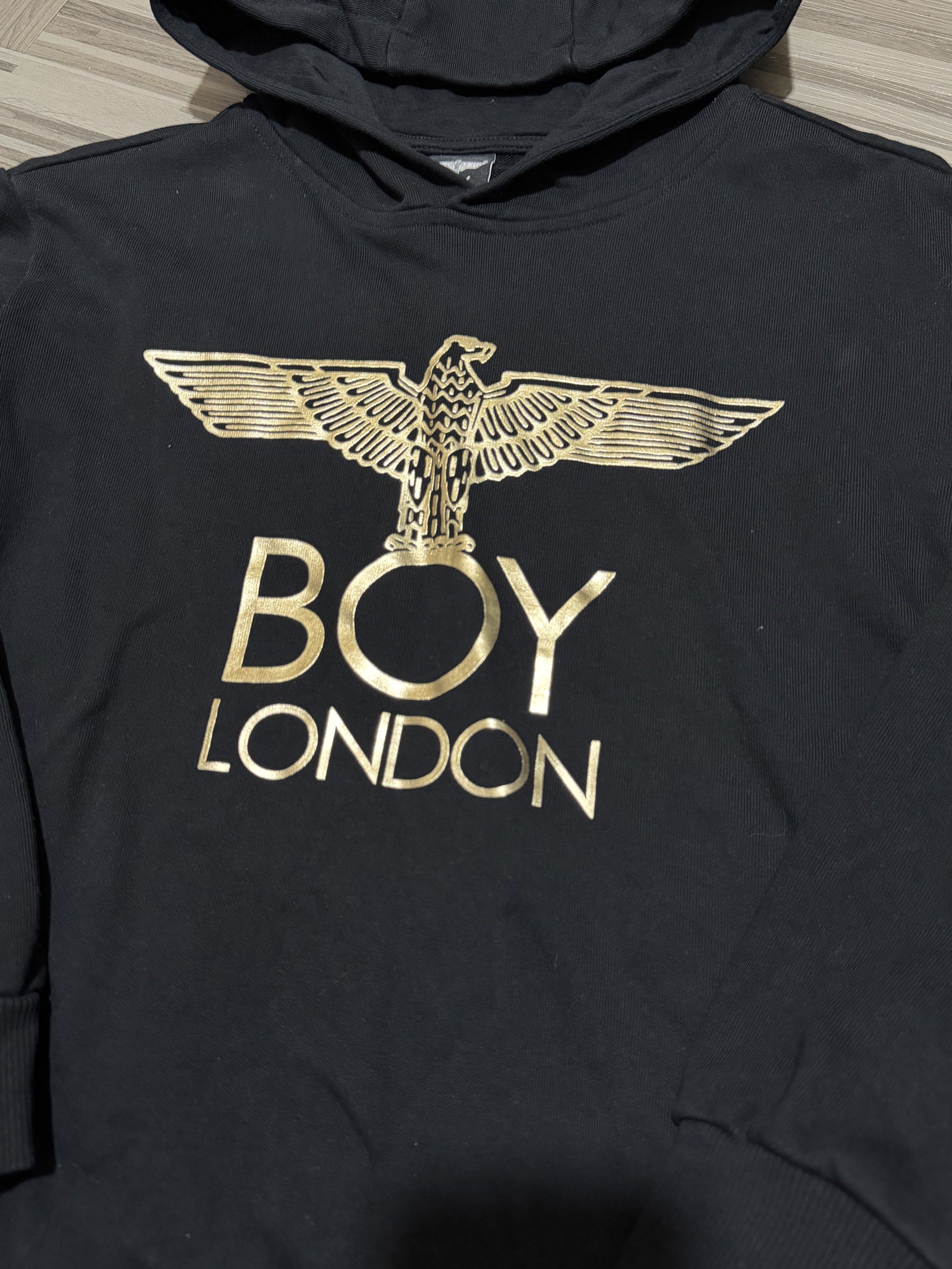 Boy London Hoodie (Category: Hoodies) located in Manila. Submitted by branded_preloved14 (Listing ID 1420987408, Image 2). Description: - Black Boy London hoodie - Features a gold eagle design - Size 150 (S-M) - Hooded with long sleeves - Suitable for casual wear -22 x 18 inches .