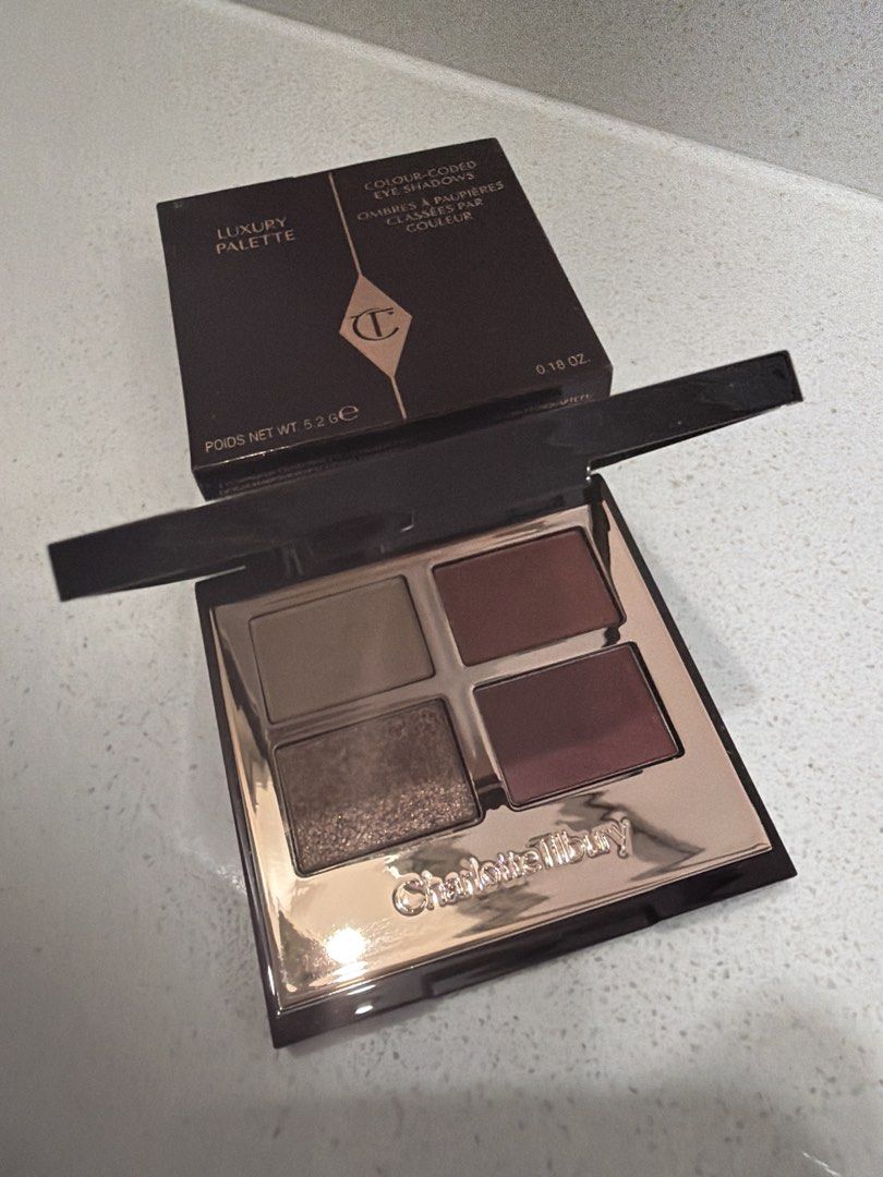 Charlotte Tilbury Luxury Palette (Category: Makeup) located in Cainta. Submitted by mycosy.life (Listing ID 1421065545, Image 2). Description: - Charlotte Tilbury Luxury Palette - Features four eyeshadow shades - Compact design with black and gold trim - Net weight: 5.2g / 0.18 oz - Includes a mix of neutral and burgundy shades.