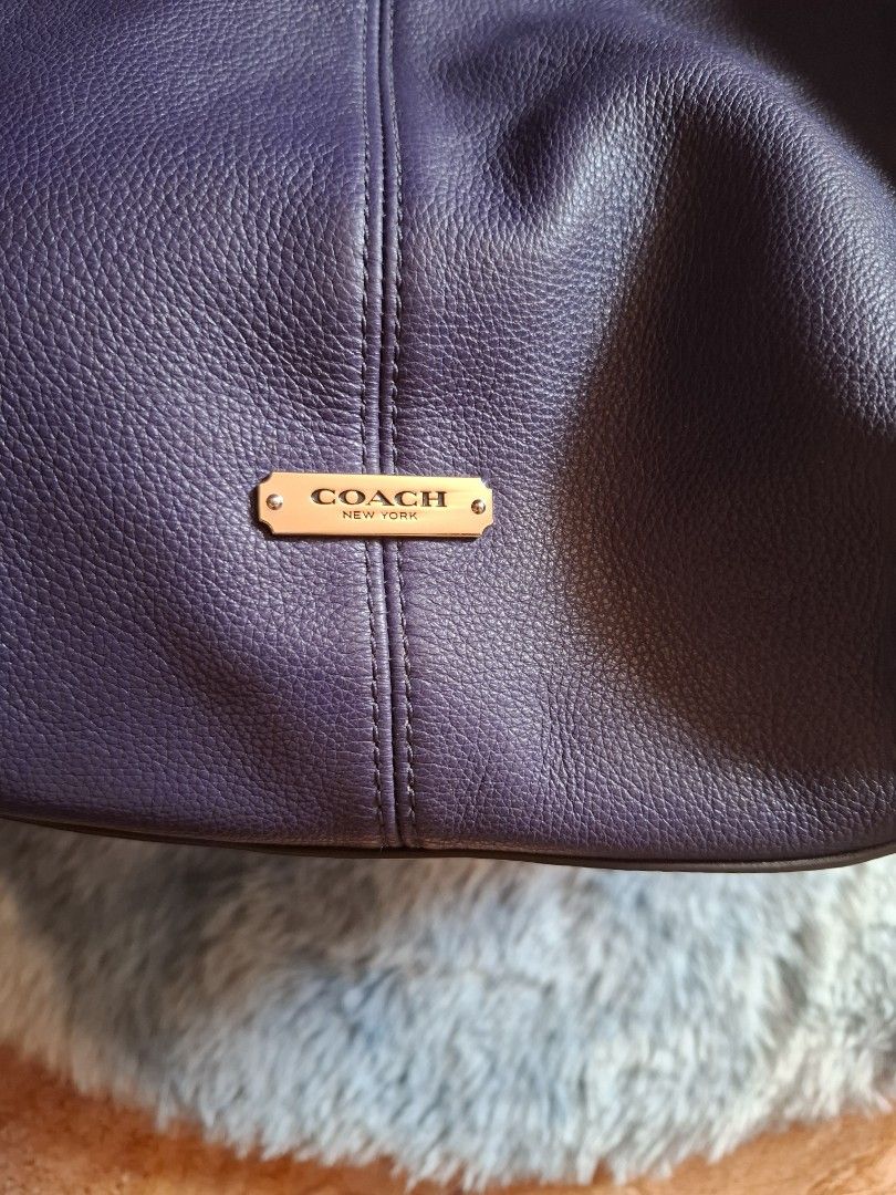 Coach Navy Blue Leather Hobo Bag (Category: Luxury Bags & Wallets) located in Bacolod City. Submitted by asheroth77 (Listing ID 1421025185, Image 3). Description: - Authentic Coach hobo bag - Crafted from navy blue leather - Comfortable single shoulder strap - Roomy interior with a convenient zip pocket - Stylish metal Coach logo on the front - Eye-catching tassel detail - Secure magnetic snap closure - Blue interior lining.
