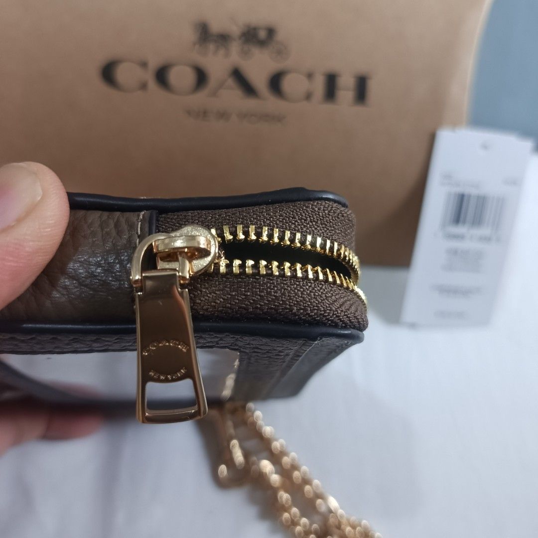 Coach Zip Card Case with Chain (Category: Luxury Bags & Wallets) located in Dagupan City. Submitted by nmcmp4 (Listing ID 1420995935, Image 3). Description: - Coach zip card case with chain - Brown leather exterior - Gold-tone zipper and chain - Features card slots - Clear ID window - Includes original packaging and tags - Coach logo embossed on front - 4 in x 3 in .