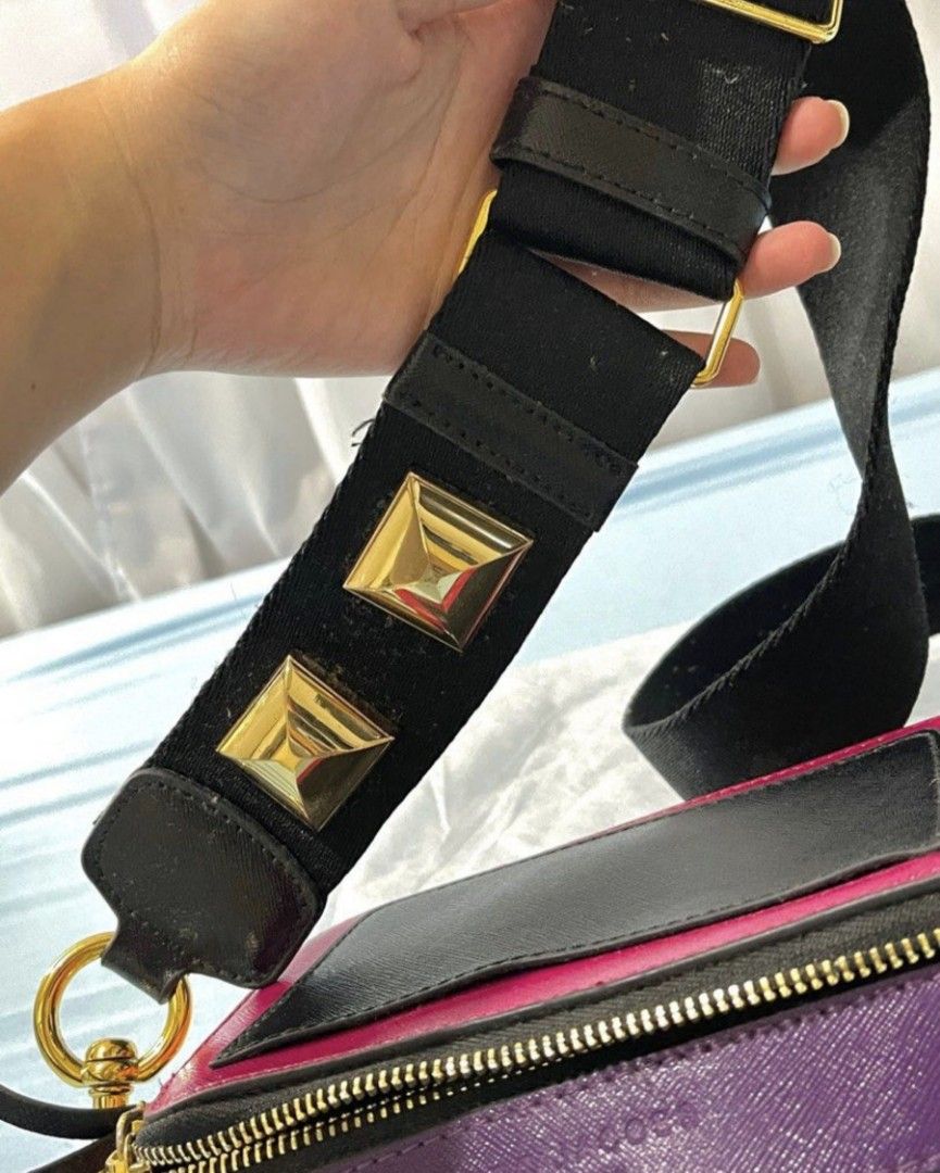 Marc Jacobs Bag (Category: Luxury Bags & Wallets) located in Bacoor. Submitted by nd.clothing (Listing ID 1420978929, Image 3). Description: Marc Jacobs The Box Bag features a vibrant color block design with a gold-tone logo. It has a detachable strap with gold hardware and studded details. The bag has a zip closure and multiple compartments. The interior is lined with purple material. The bag has a black strap and gold hardware..