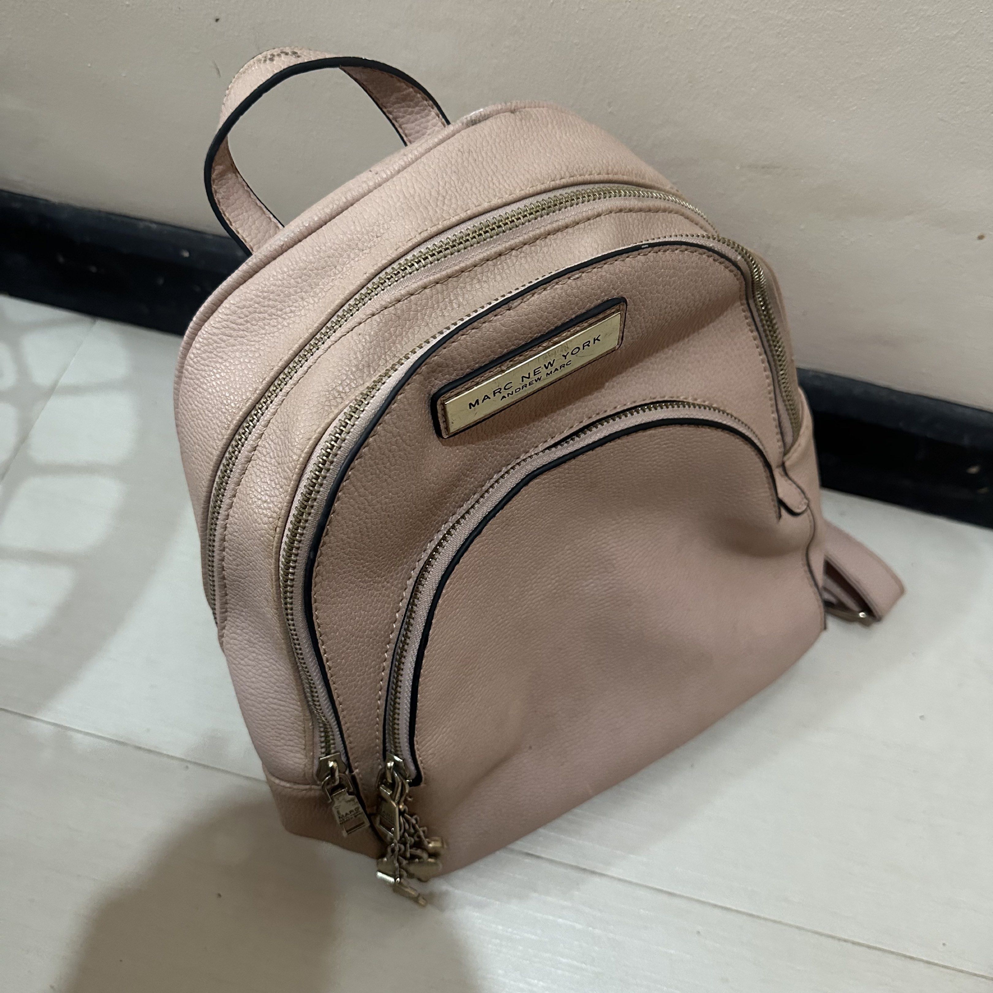 Authentic Marc New York Blush Pink Leather Backpack with Charm Keychains (Category: Backpacks) located in Cavite. Submitted by fiarteau (Listing ID 1420948647, Image 3). Description: - Marc New York backpack in blush pink. - Bought in US for around PHP 4000 - Gold-toned hardware. - Multiple zippered compartments (front pocket and main compartment). - Interior pockets. - Top handle and adjustable shoulder straps. - Includes brand charm. - With sig