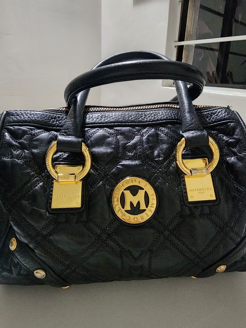 Metrocity Black Handbag (Category: Luxury Bags & Wallets) located in Manila. Submitted by babygirl.luxxe (Listing ID 1421112966, Image 3). Description: Black Metrocity handbag with gold-tone hardware. Features a quilted design, top handles, and a zip closure. Includes gold-tone accents and a Metrocity logo on the front. Structure is very good faded lang sa mga hardware.