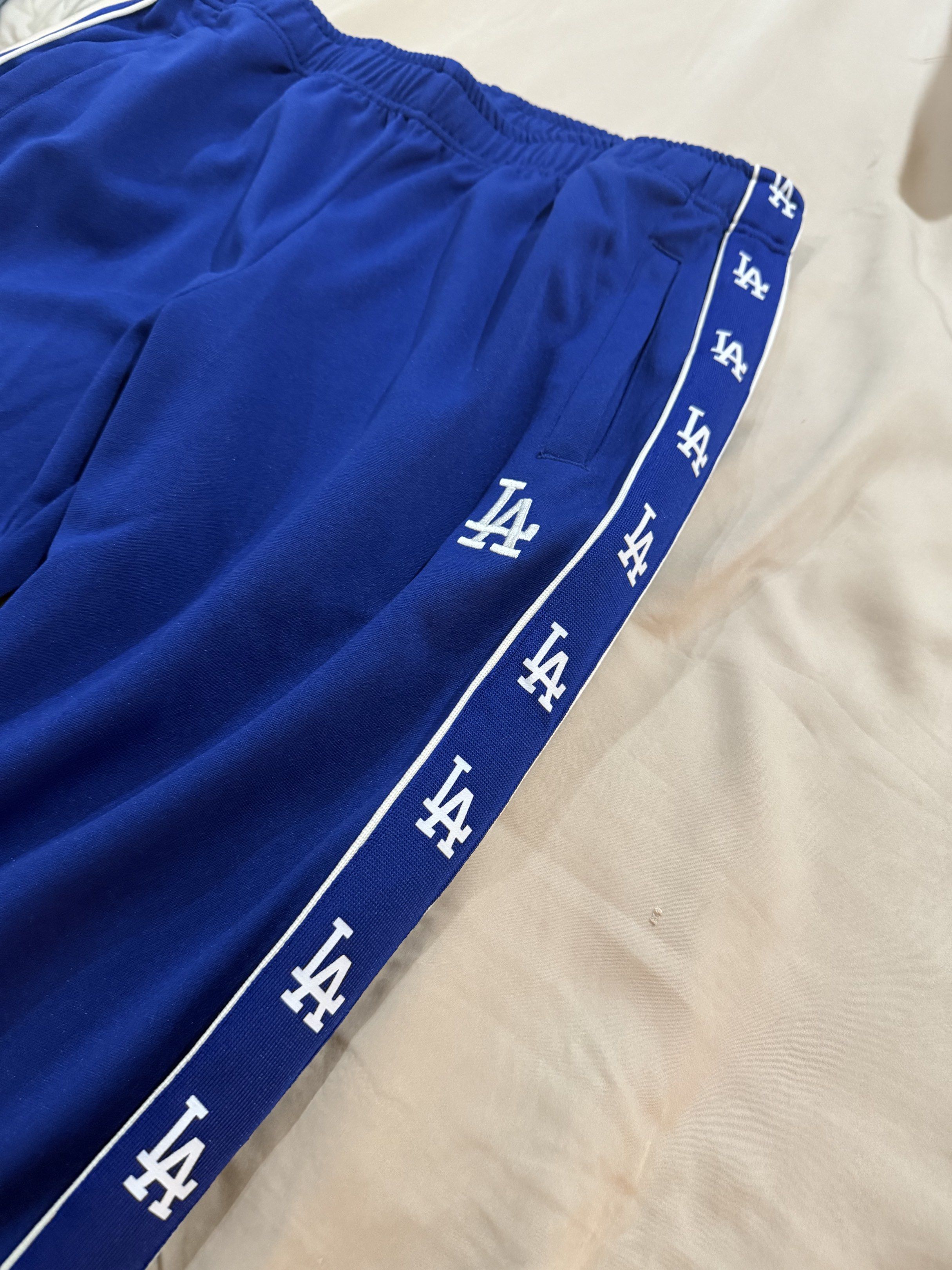 MLB Los Angeles Dodgers side-tape track pants (Category: Joggers) located in Manila. Submitted by archivesbyelle (Listing ID 1421075864, Image 2). Description: - MLB Los Angeles Dodgers track pants - Size: M - Features side tape design with LA logo - Color: Blue - Condition: Excellent - Genuine merchandise - Never been used, I bought this from the mall but unfortunately I cut off the tag already.