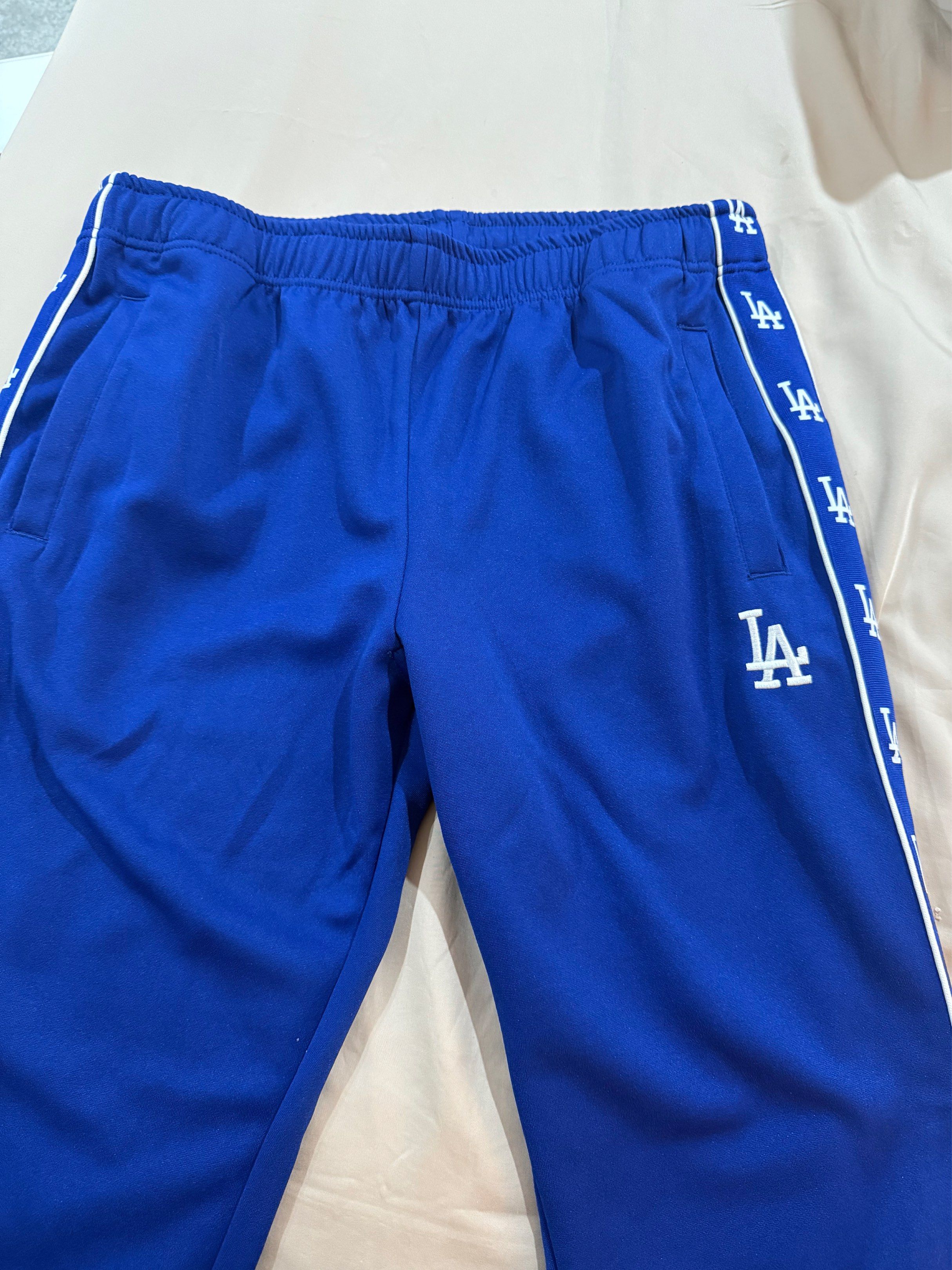 MLB Los Angeles Dodgers side-tape track pants (Category: Joggers) located in Manila. Submitted by archivesbyelle (Listing ID 1421075864, Image 1). Description: - MLB Los Angeles Dodgers track pants - Size: M - Features side tape design with LA logo - Color: Blue - Condition: Excellent - Genuine merchandise - Never been used, I bought this from the mall but unfortunately I cut off the tag already.