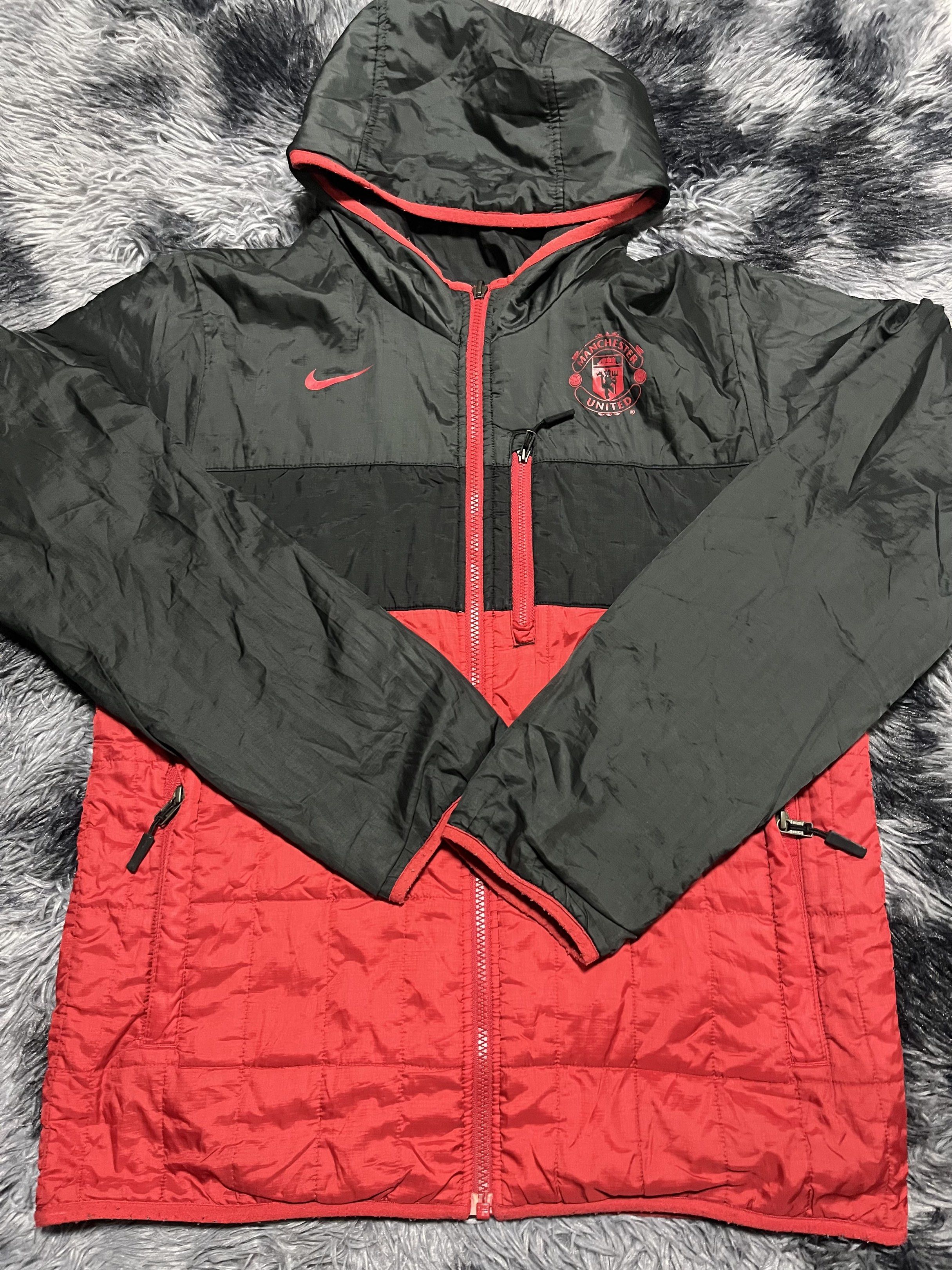 Nike Manchester United Reversible Jacket (Category: Coats, Jackets and Outerwear) located in Santa Rosa. Submitted by _unclethrifts (Listing ID 1421096235, Image 2). Description: - Reversible Manchester United jacket. - One side: Black with red accents. - Other side: Red with black accents. - Includes a hood. - Full-length zipper. - Nike logo on the chest. - Size tag present..