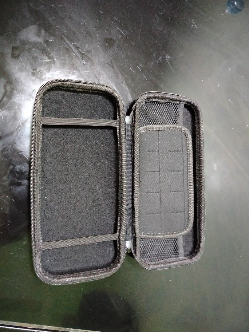Nintendo Switch OLED Case (Category: Cases & Covers) located in Manila. Submitted by mikel623 (Listing ID 1421116763, Image 2). Description: - Protective case for Nintendo Switch OLED - Zippered closure for secure storage - Soft interior to prevent scratches - Includes compartments for console and accessories - Sleek black design - Features the Switch OLED logo.