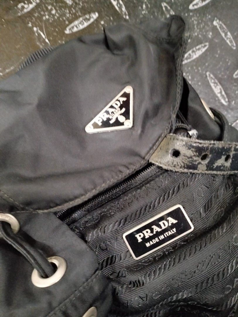 Prada Nylon Backpack (Category: Luxury Bags & Wallets) located in Manila. Submitted by style.culture (Listing ID 1420998695, Image 2). Description: - Authentic Prada backpack - Black nylon material - Prada logo on front and interior - Adjustable shoulder straps - Multiple compartments - Interior lining with Prada logo pattern - Made in Italy - Zipper closure.