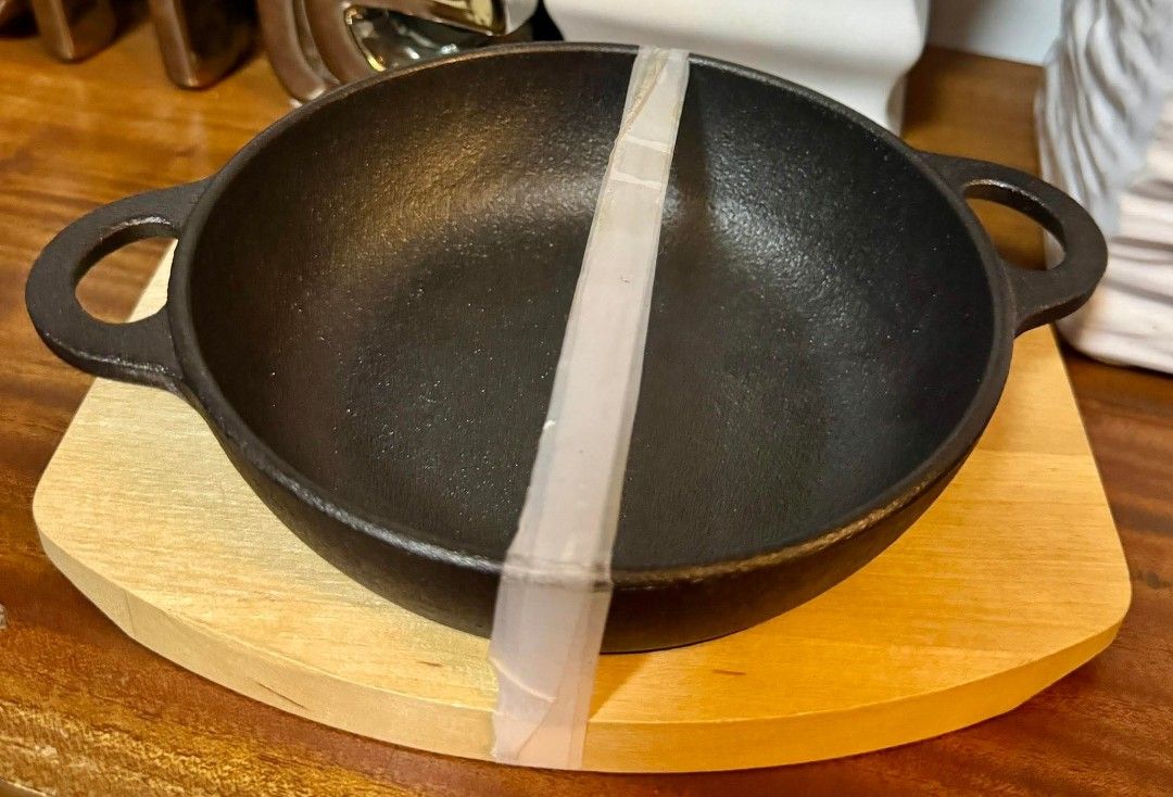 Cast Iron Pan with Wooden Base (Category: Cookware & Accessories) located in Manila. Submitted by ormelynmal86309 (Listing ID 1421185260, Image 1). Description: - New, unused cast iron pan - Includes a wooden base - Features two loop handles for easy handling - Ideal for home cooks and chefs - Ready for your next culinary creation!.
