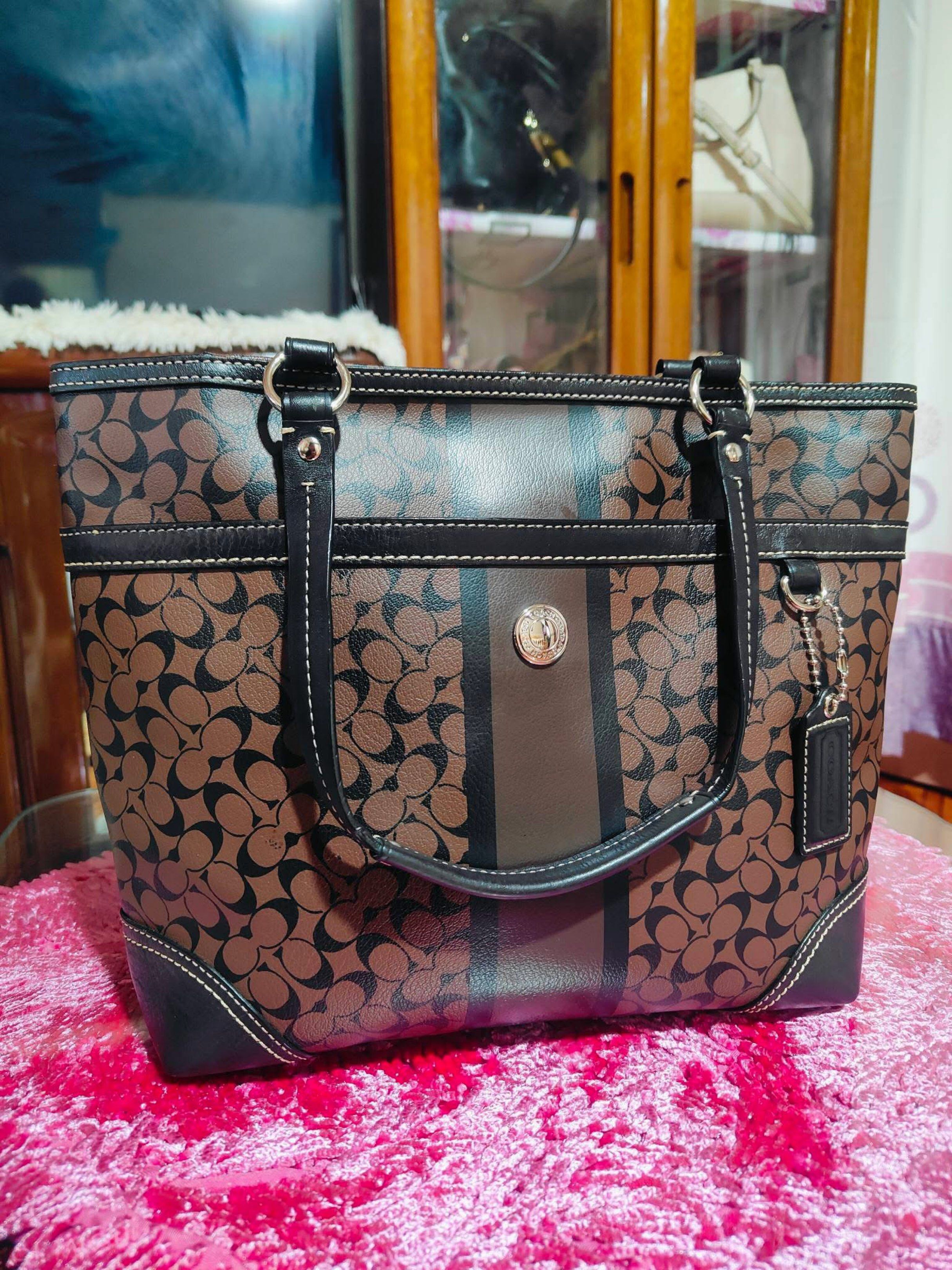 Coach Signature Tote Bag (Category: Luxury Bags & Wallets) located in Baguio. Submitted by beatriz468 (Listing ID 1421140867, Image 2). Description: - Authentic Coach tote bag - Brown and black signature pattern with central stripe - Double handles - Zip closure - Coach hang tag included - Silver-tone hardware - Coach logo emblem on front - Interior lined with signature pattern.