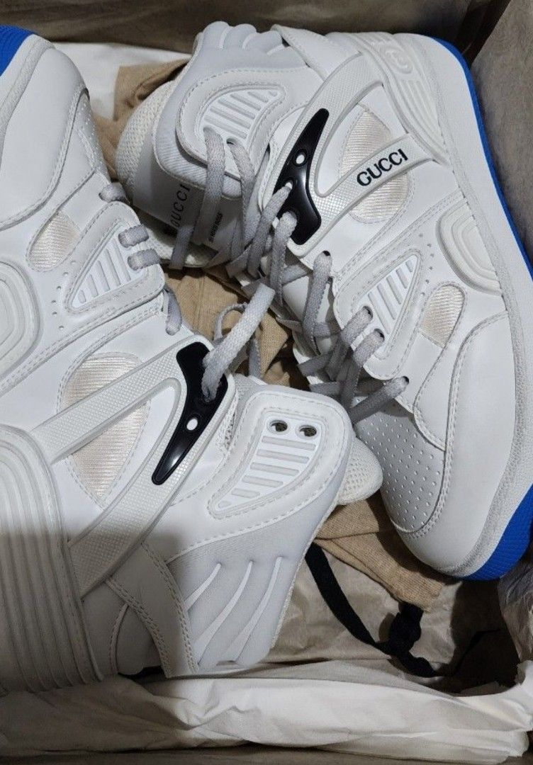 Gucci Basket High-Top Sneakers - White (Category: Sneakers) located in Manila. Submitted by microus (Listing ID 1421162613, Image 2). Description: - Authentic Gucci Basket high-top sneakers - Color: White - Size: 7 but runs big - Features Gucci logo on tongue and side - Blue rubber sole with Gucci logo and bee design - Includes original box.