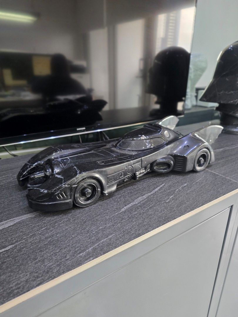Hand Carved 1989 Batman Batmobile in Solid Nero Marquina Marble (Category: Vehicle & Diecast Models) located in Mandaluyong City. Submitted by lbear29 (Listing ID 1421130612, Image 1). Description: Hand carved from a single block of marble with exceptional details - Collector's item - One of a kind Marble fan art - Batmobile collectible - Sleek, dark design - Intricate detailing - Iconic Batmobile shape - Visible wheels and aerodynamic features -