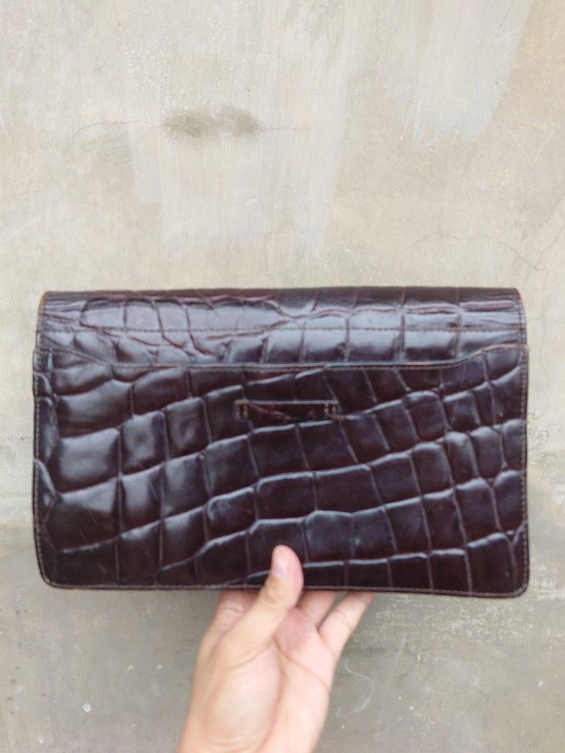 Jean Paul Gaultier Crocodile Clutch (Category: Luxury Bags & Wallets) located in Caloocan City. Submitted by thon0806 (Listing ID 1421143502, Image 3). Description: - Dark brown clutch - Crocodile skin pattern - Interior zipper pocket - Brand label - Clasp closure - Minor wear on edges - with strap .