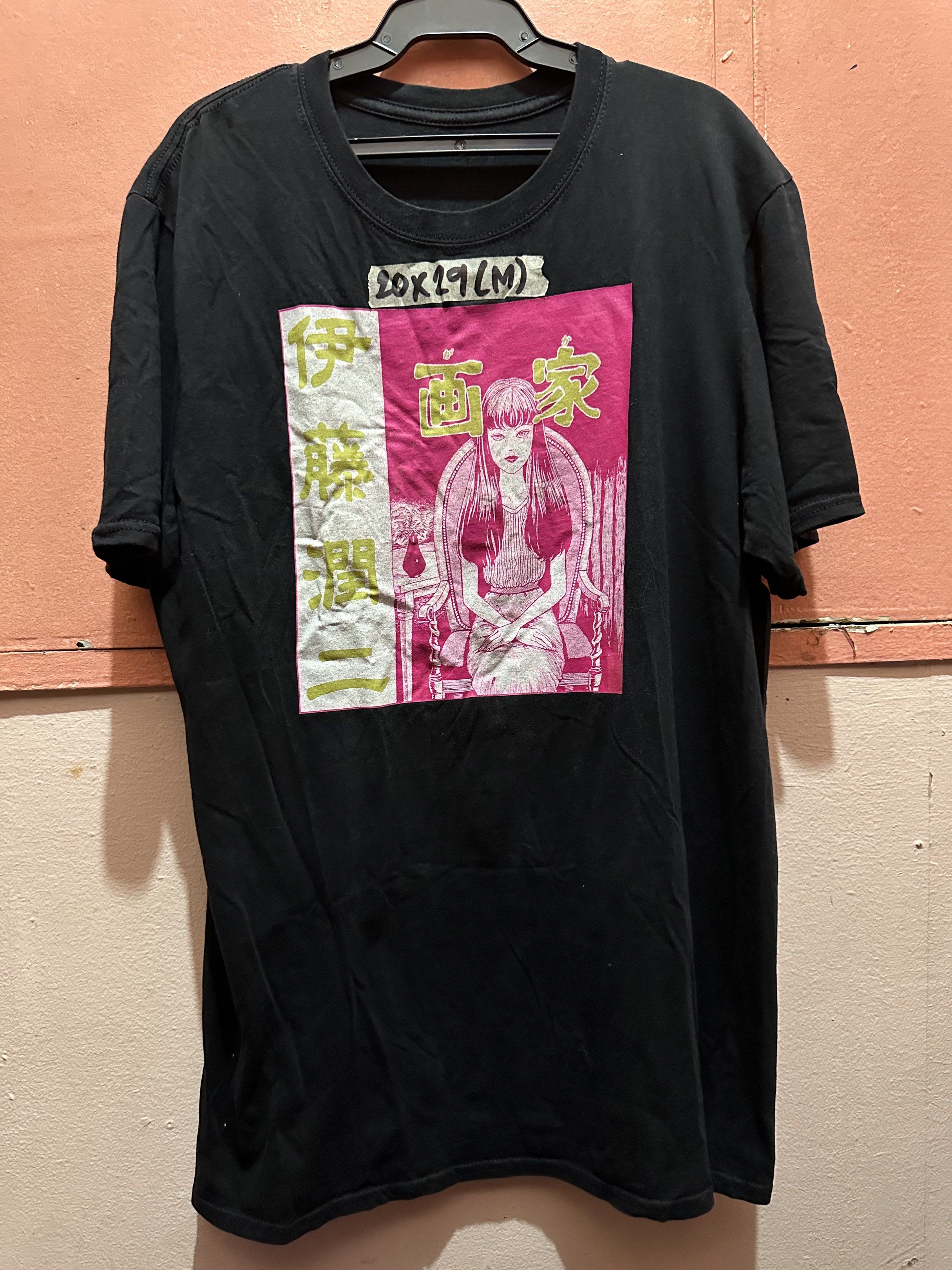 Junji Ito Collection Graphic Tee - Size M (Category: Tshirts & Polo Shirts ) located in Manila. Submitted by juanabanana (Listing ID 1421277317, Image 1). Description: Black Junji Ito Collection graphic tee. Features a pink and white graphic on the front. The size is M, with measurements of 20x29 inches. The back of the shirt is plain black. The shirt has a round neckline and short sleeves. Needs wash.