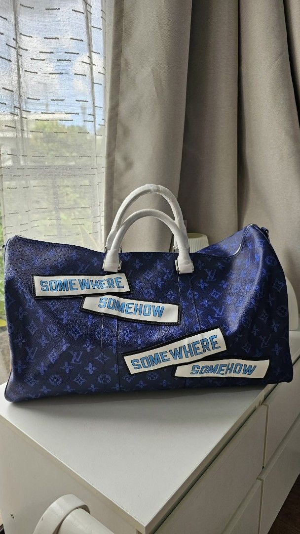 Louis Vuitton Duffle Bag Somewhere Somehow (Category: Luxury Bags & Wallets) located in Caloocan City. Submitted by marie_0812 (Listing ID 1421156915, Image 1). Description: - Louis Vuitton duffle bag - Spring/Summer 2021 collection - Navy blue monogram design with white accents - Features "SOMEWHERE SOMEHOW" patches - Detachable shoulder strap included - Spacious interior - Secure zipper closure - Gold hardware - Louis Vuitton Paris label inside