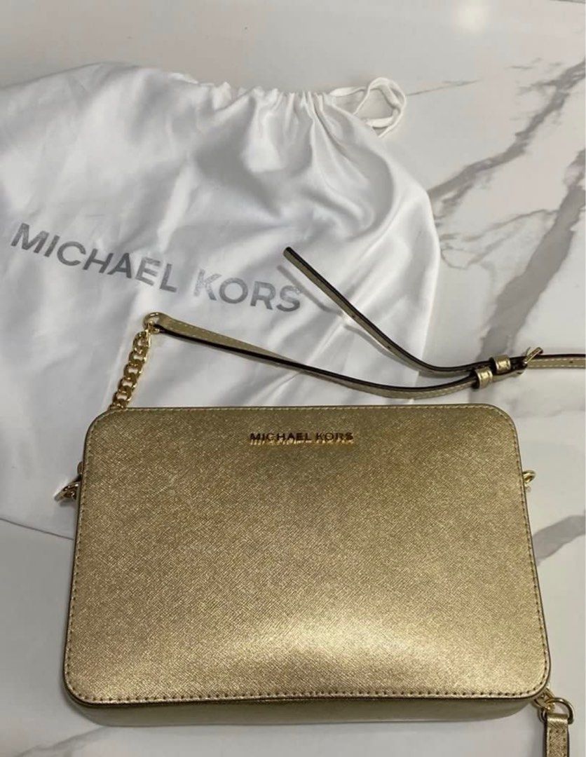 Michael Kors Gold Crossbody Bag (Category: Luxury Bags & Wallets) located in Quezon City. Submitted by davenue (Listing ID 1421174364, Image 2). Description: - Michael Kors gold crossbody bag - Chain strap included - Comes with dust bag - Rectangular shape with MK logo - Detachable strap for versatility - Suitable for everyday or special events.