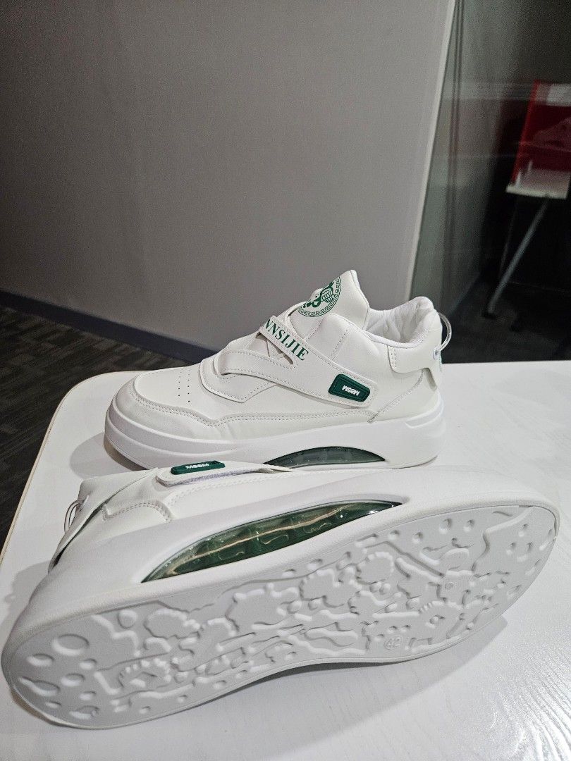 NNSIJIE White Sneakers (Category: Sneakers) located in Manila. Submitted by honeypatch (Listing ID 1421223957, Image 3). Description: - White sneakers with a unique design - Features a strap with "NNSIJIE" branding - Visible air cushion sole - Green accent on the strap - Versace like logo on the tongue - Thick sole for added comfort and style - RFS: Originally bought for Monito Monita but recipient went AWOL so Im selling it instead. - Brand New 